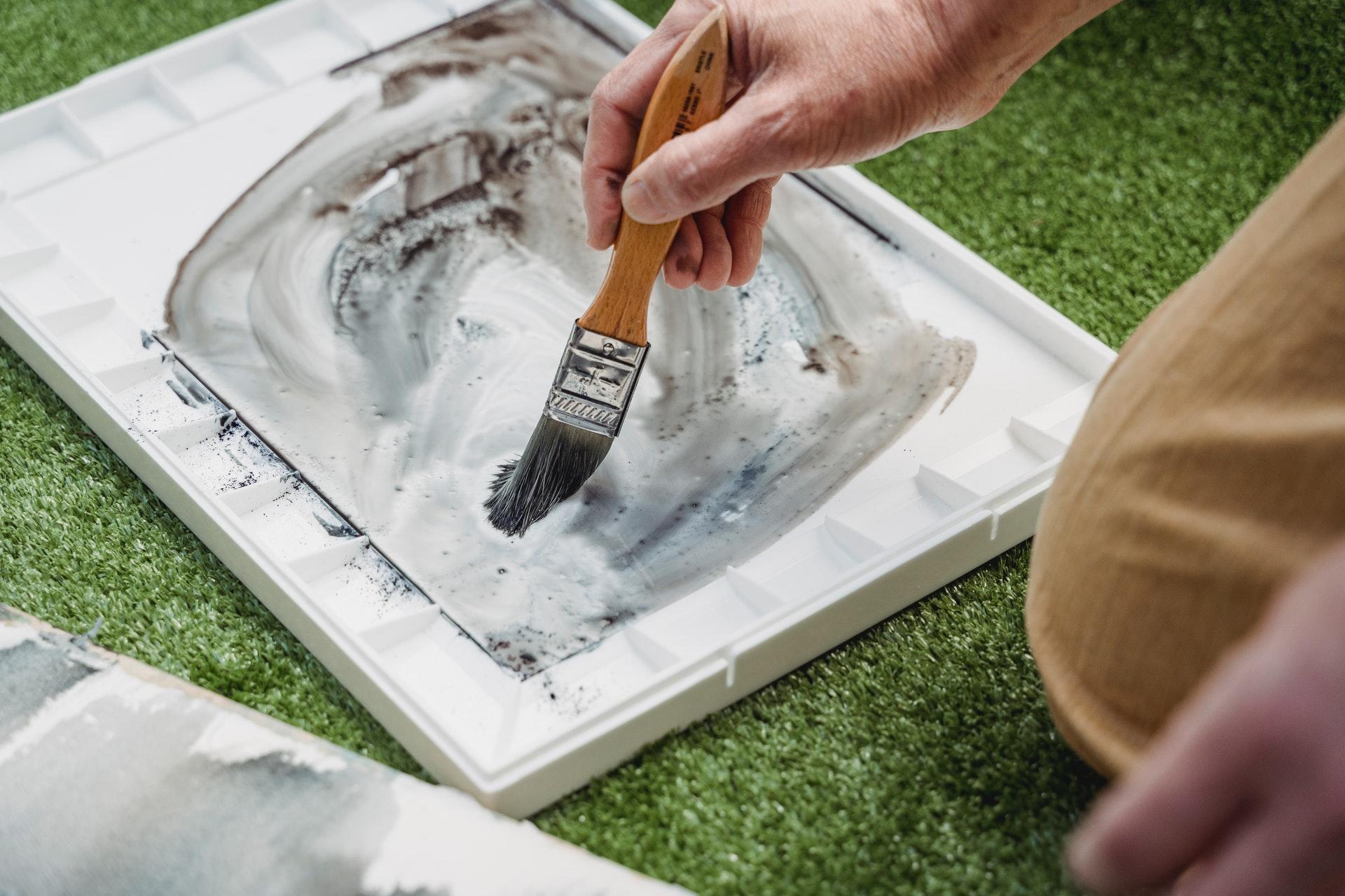 Persoon schildert in boek op de grond