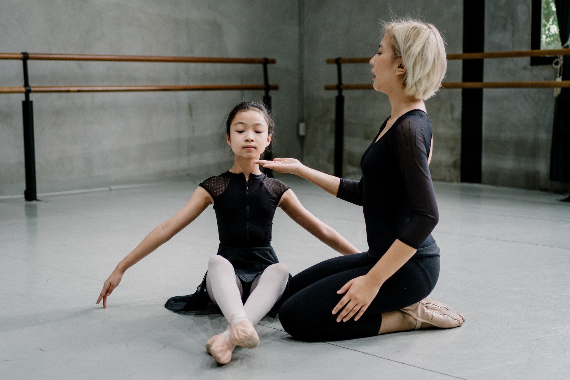 Balletleerkracht geeft jonge ballerina tips