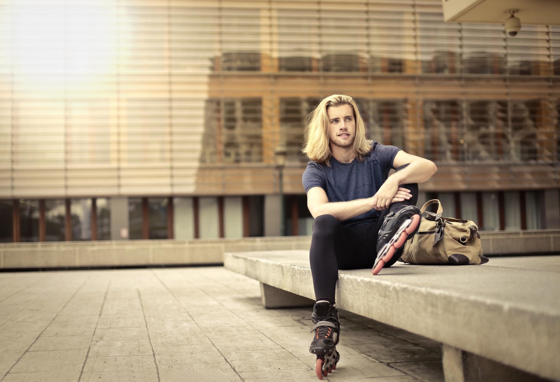 Inline skater zit op bank