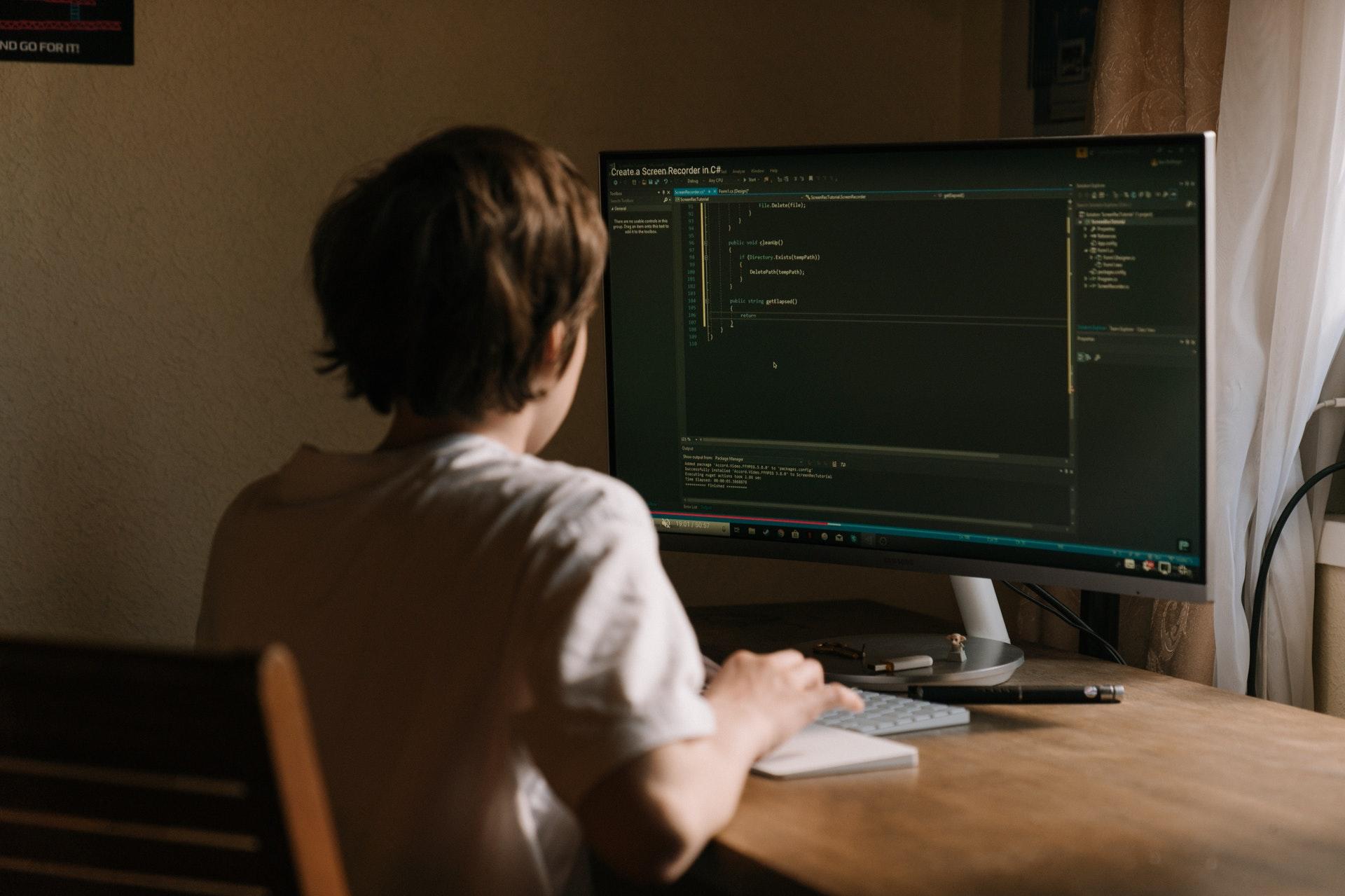 Jongen programmeert op computer