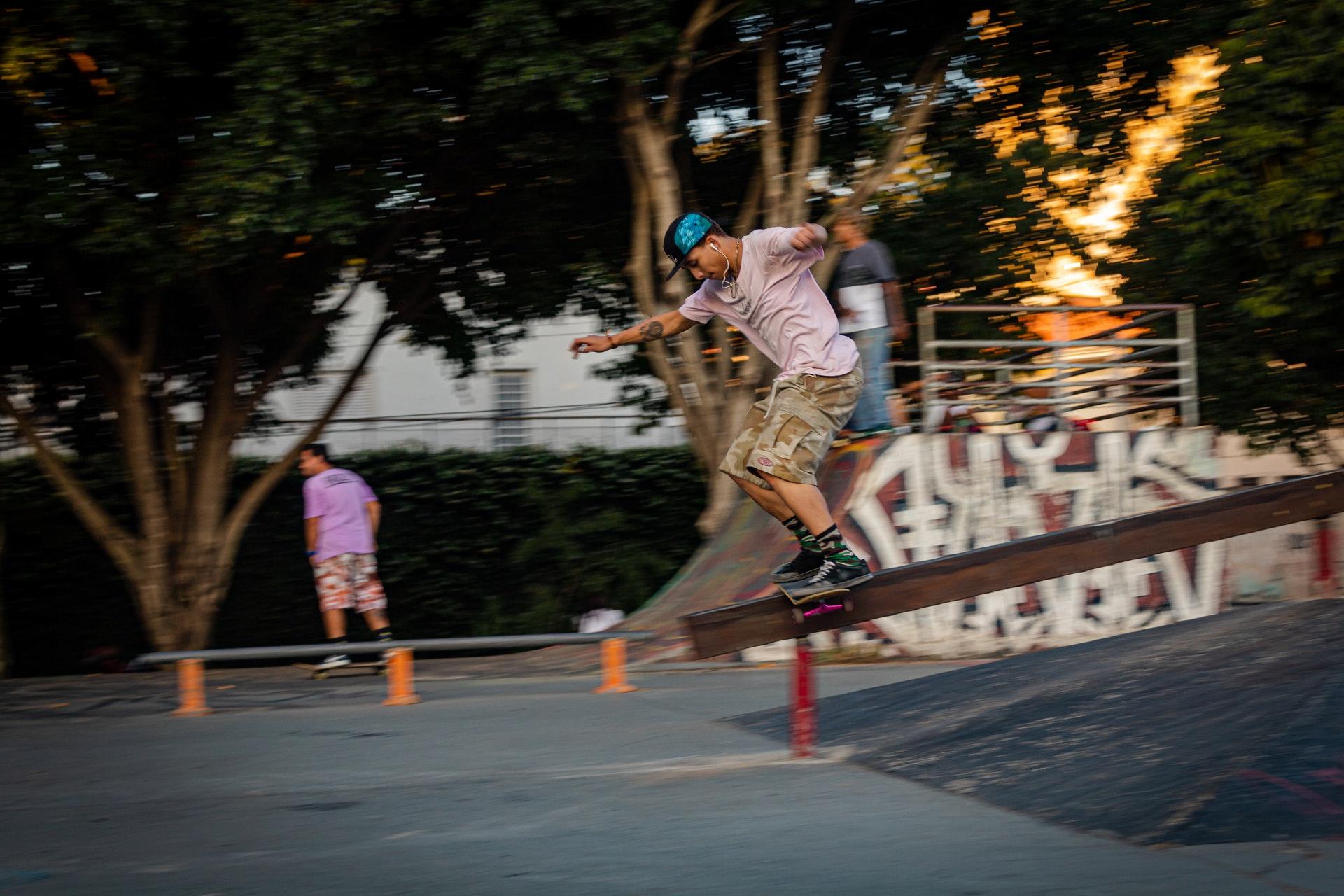 Skater doet grind op een metalen bar