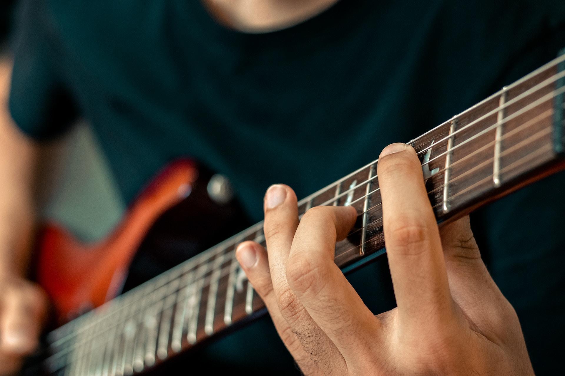 Man oefent akkoorden op gitaar