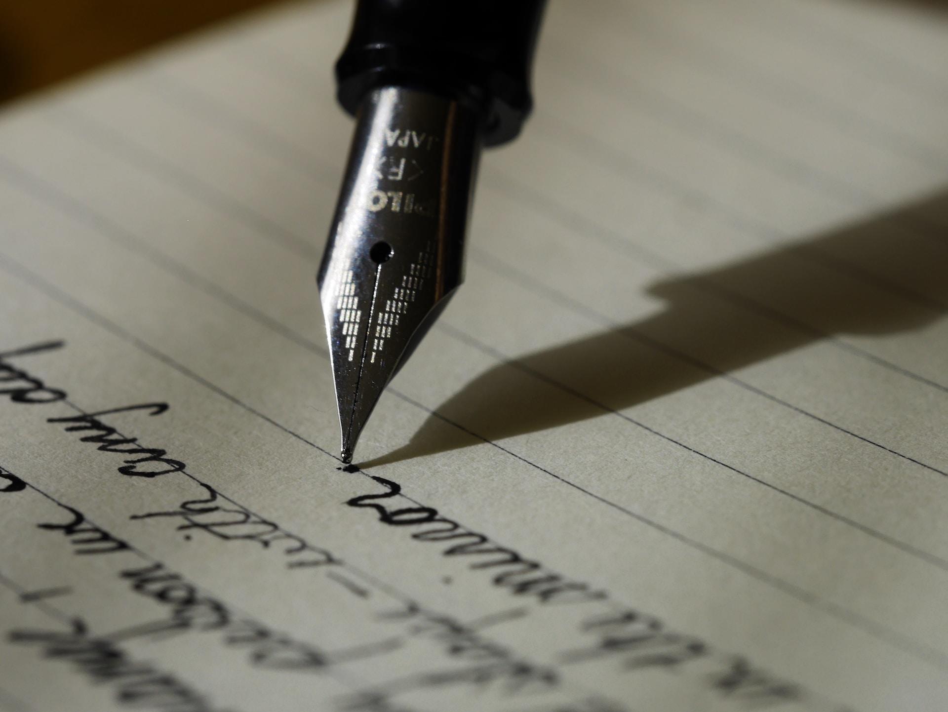 Pen schrijft in cursusblok