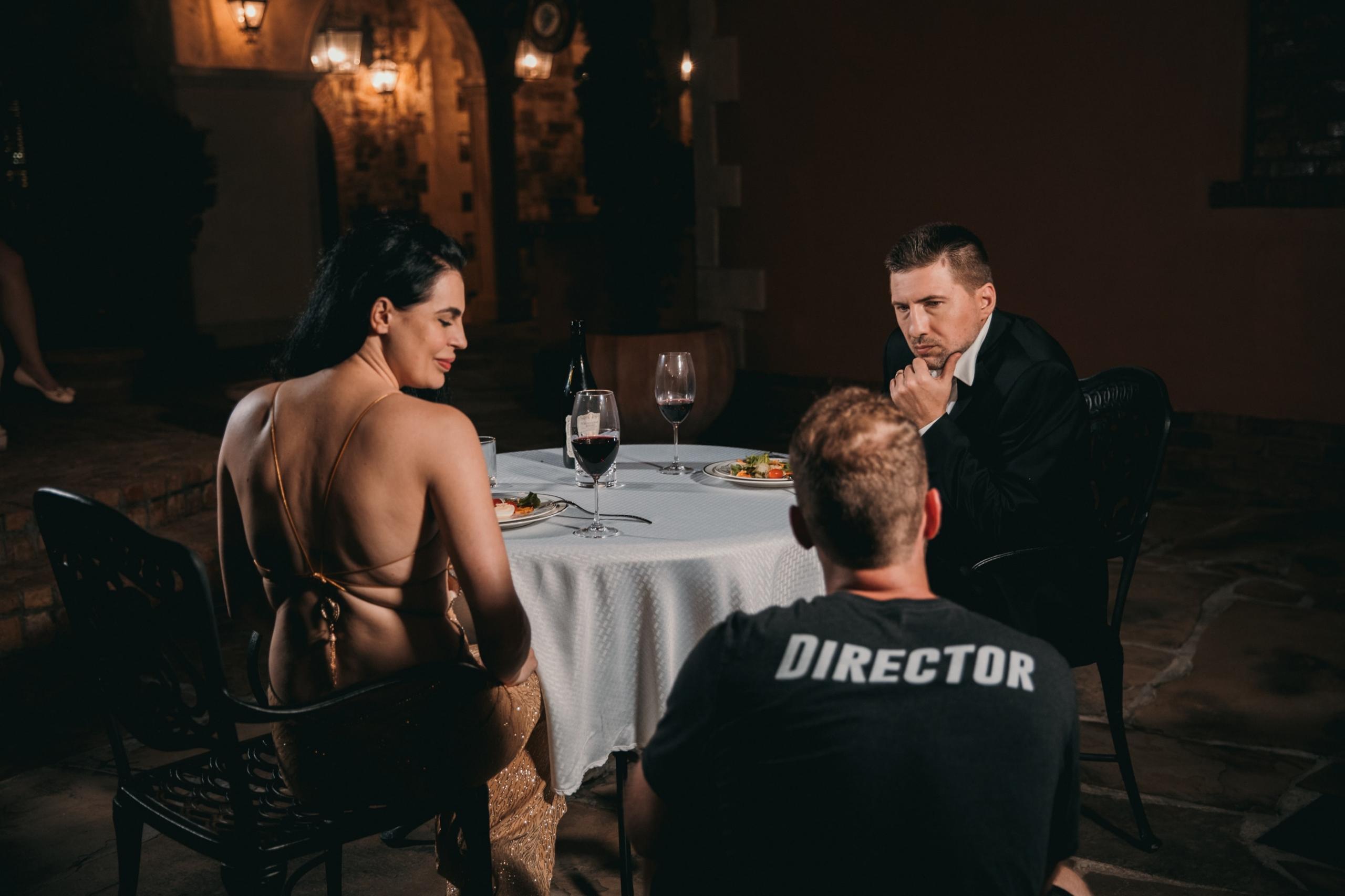 Regisseur geeft tips aan acteur rond een tafel