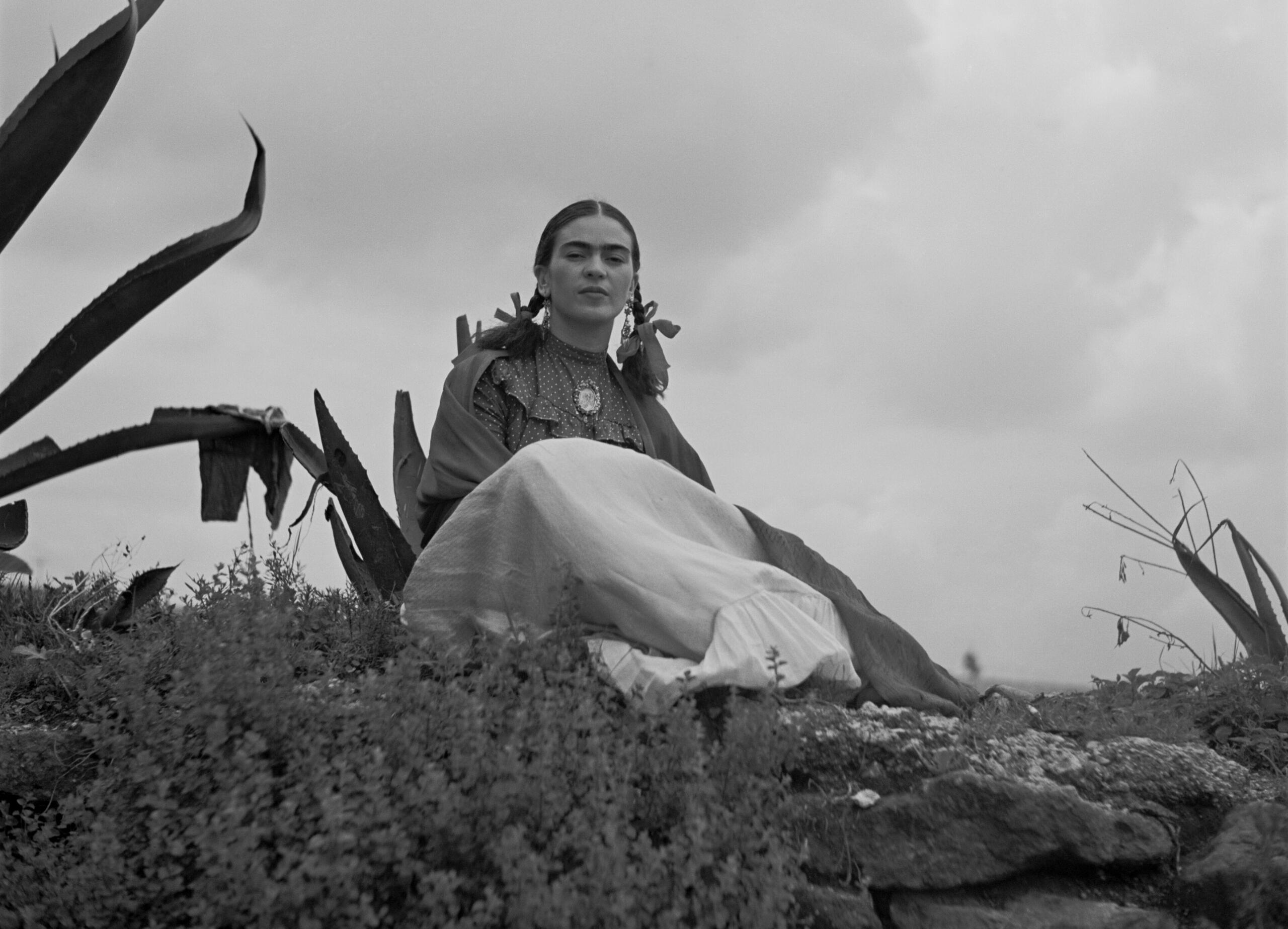 Frida Kahlo, zittend naast een agave ergens in Mexico.