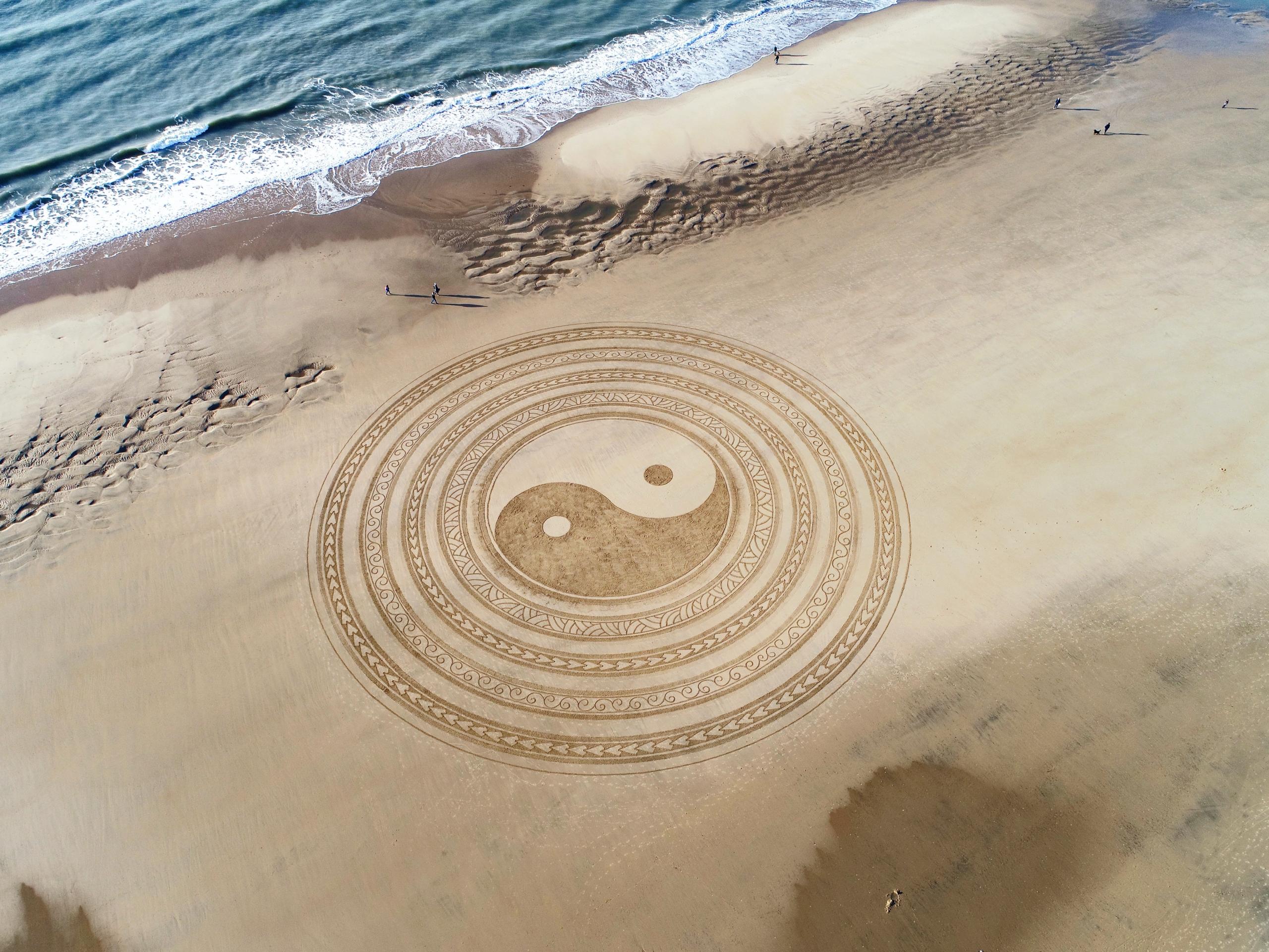 Yin en Yang tekening op strand