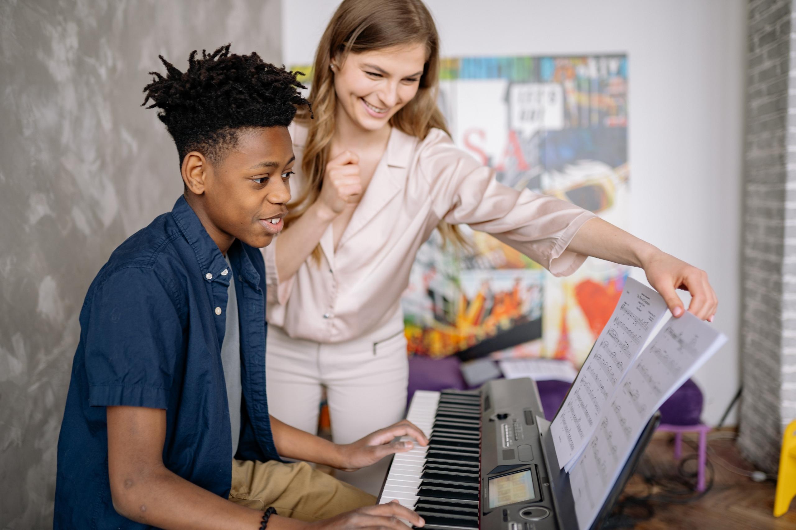 Vrouw leert piano aan jonge