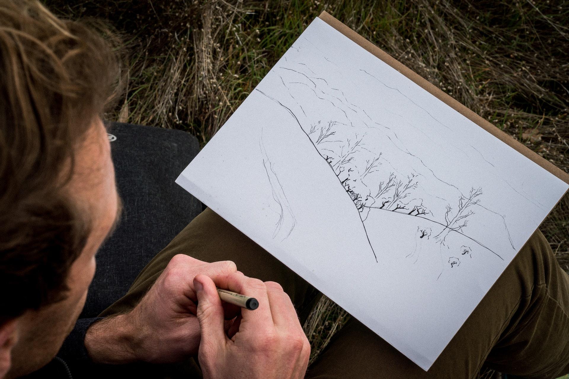 Persoon tekent landschap