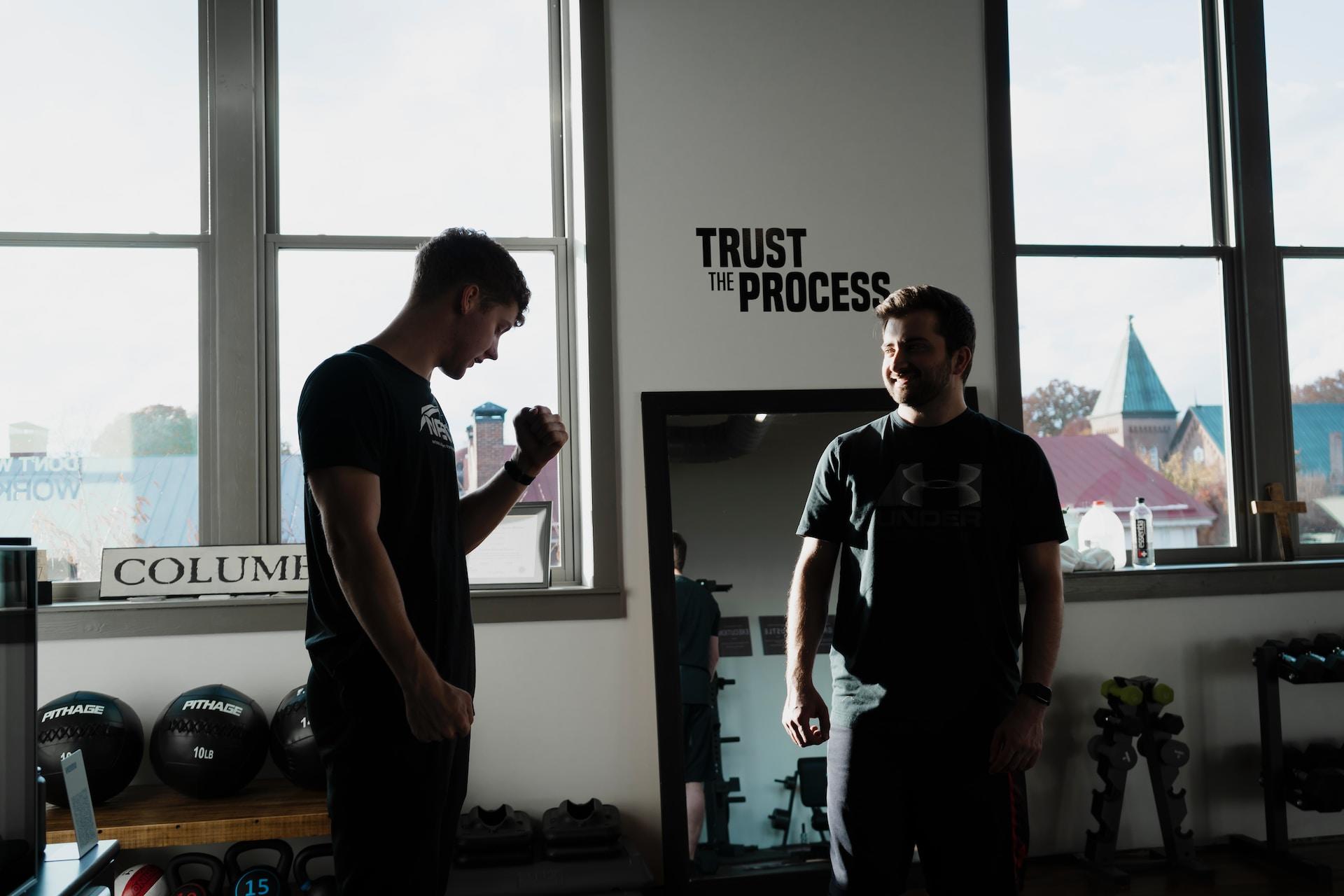 man krijgt uitleg van personal trainer