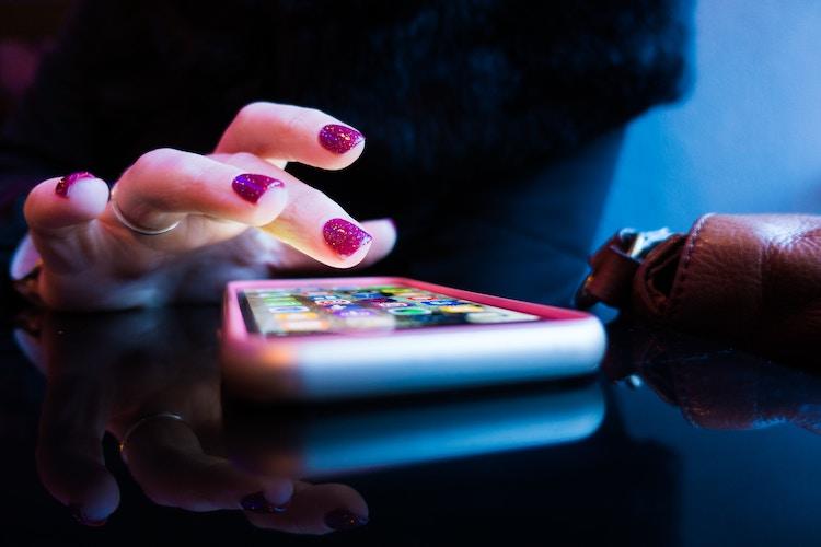 vrouw tokkelend op telefoon doorheen applicaties