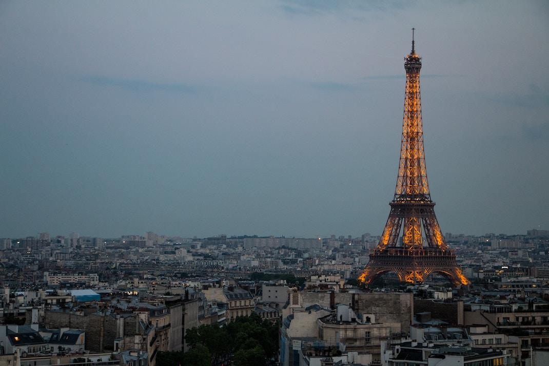 zicht op Parijs en belichte Eiffeltoren op het vallen van de avond