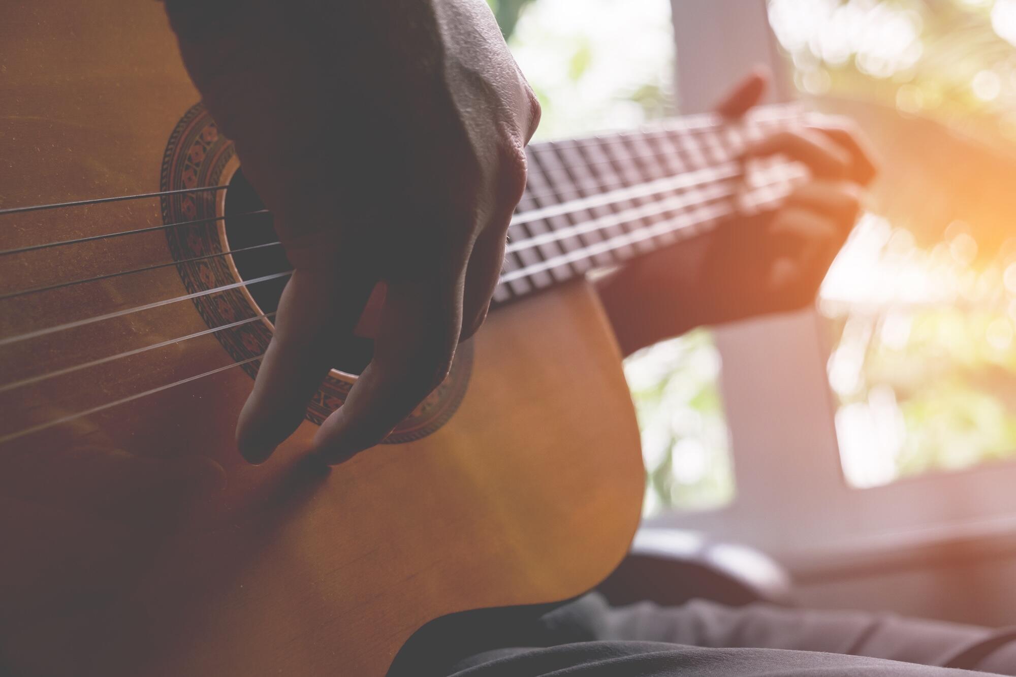 Une personne est en train de jouer de la guitare