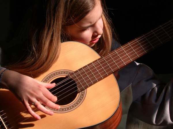 Jeune élève apprenant à jouer de la guitare