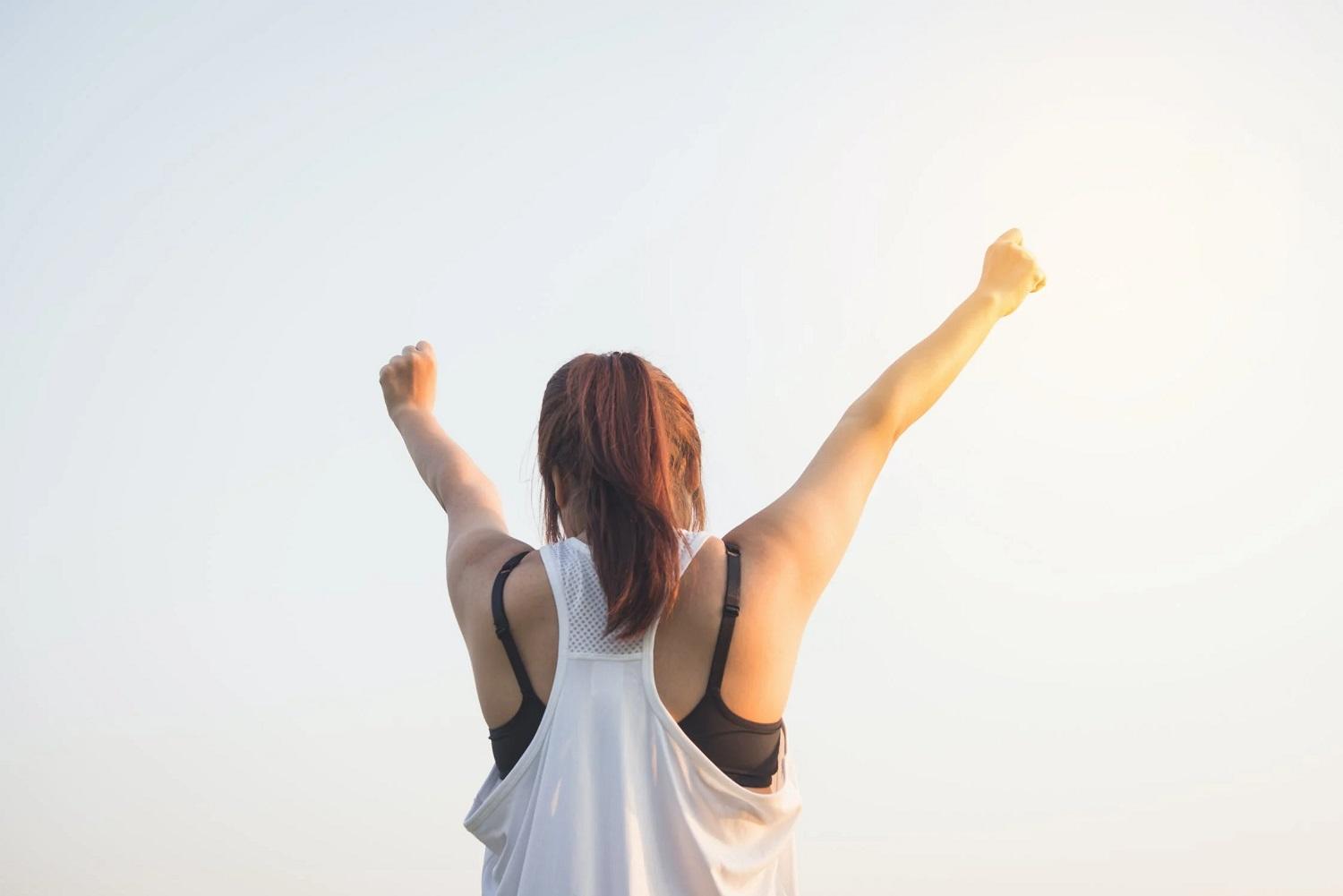 Une personne lèvent les bras en signe de motivation. 