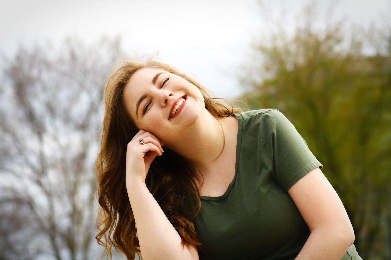 jeune femme souriante dans les bois sous un ciel blanc