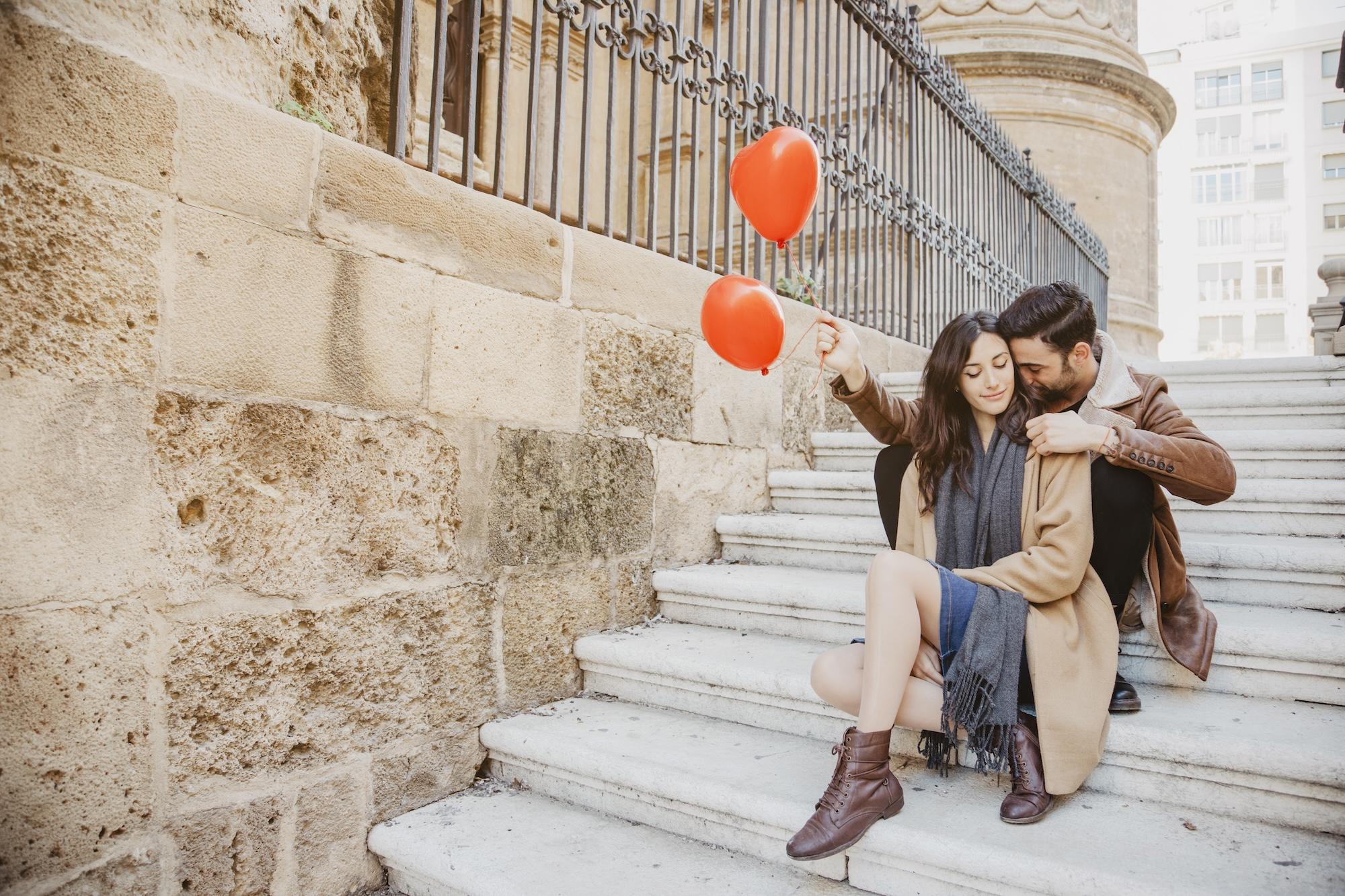 Couple mignon avec des ballons dans les escaliers