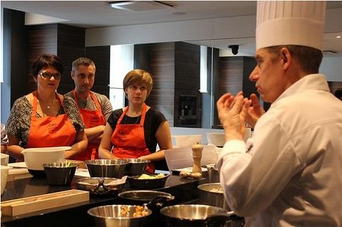 Des amateurs de cuisine suivent un atelier culinaire haut de gamme à l'école Bocuse.