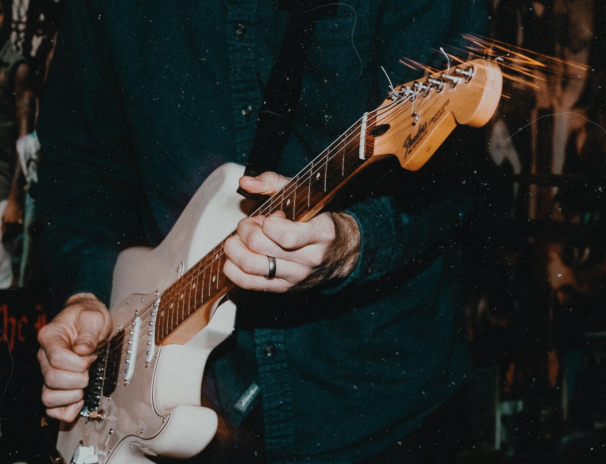 Des mains jouent de la guitare électrique