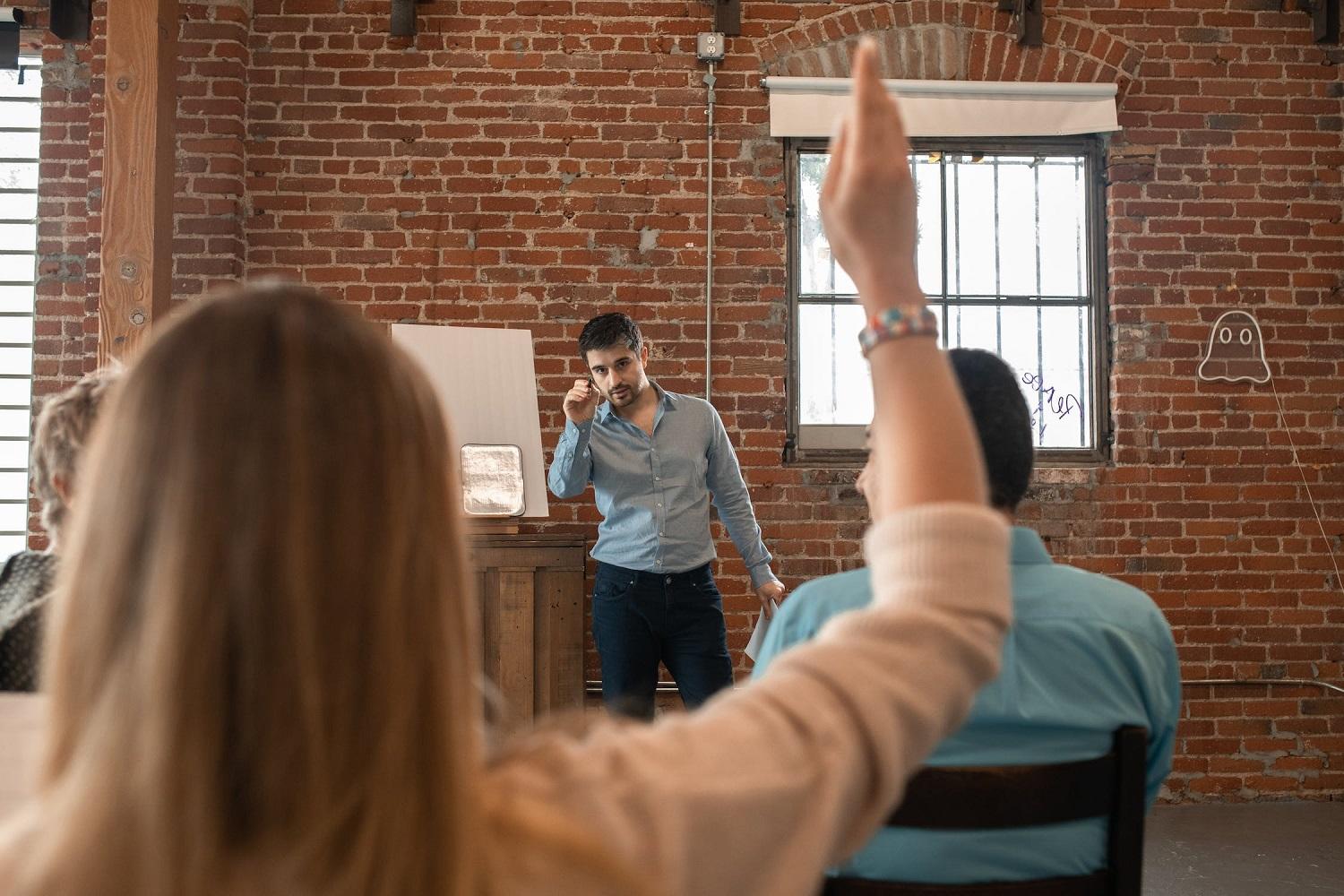 Une élève lève la main en cours d'anglais.