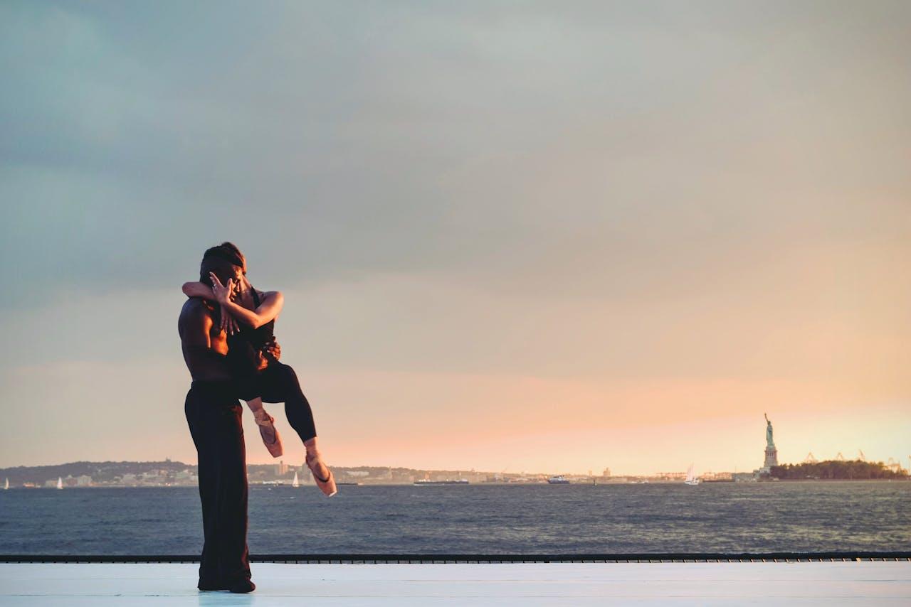 Un couple danse au coucher du soleil.