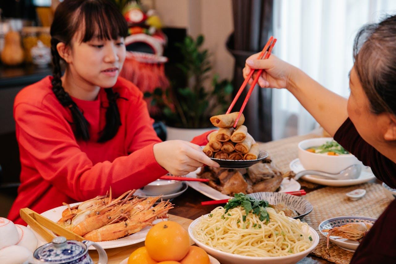 Maman qui prend un nem dans l'assiette tendue par sa fille.