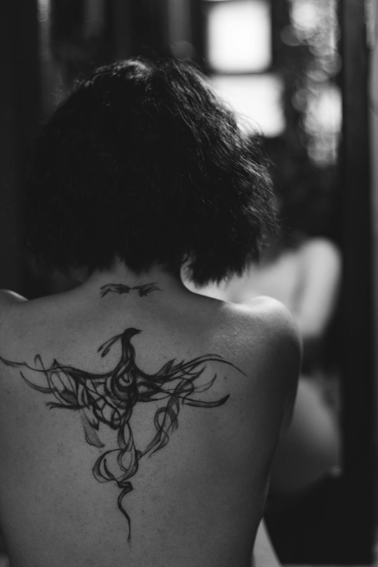 Tatouage de phénix dans le dos d'une femme. 