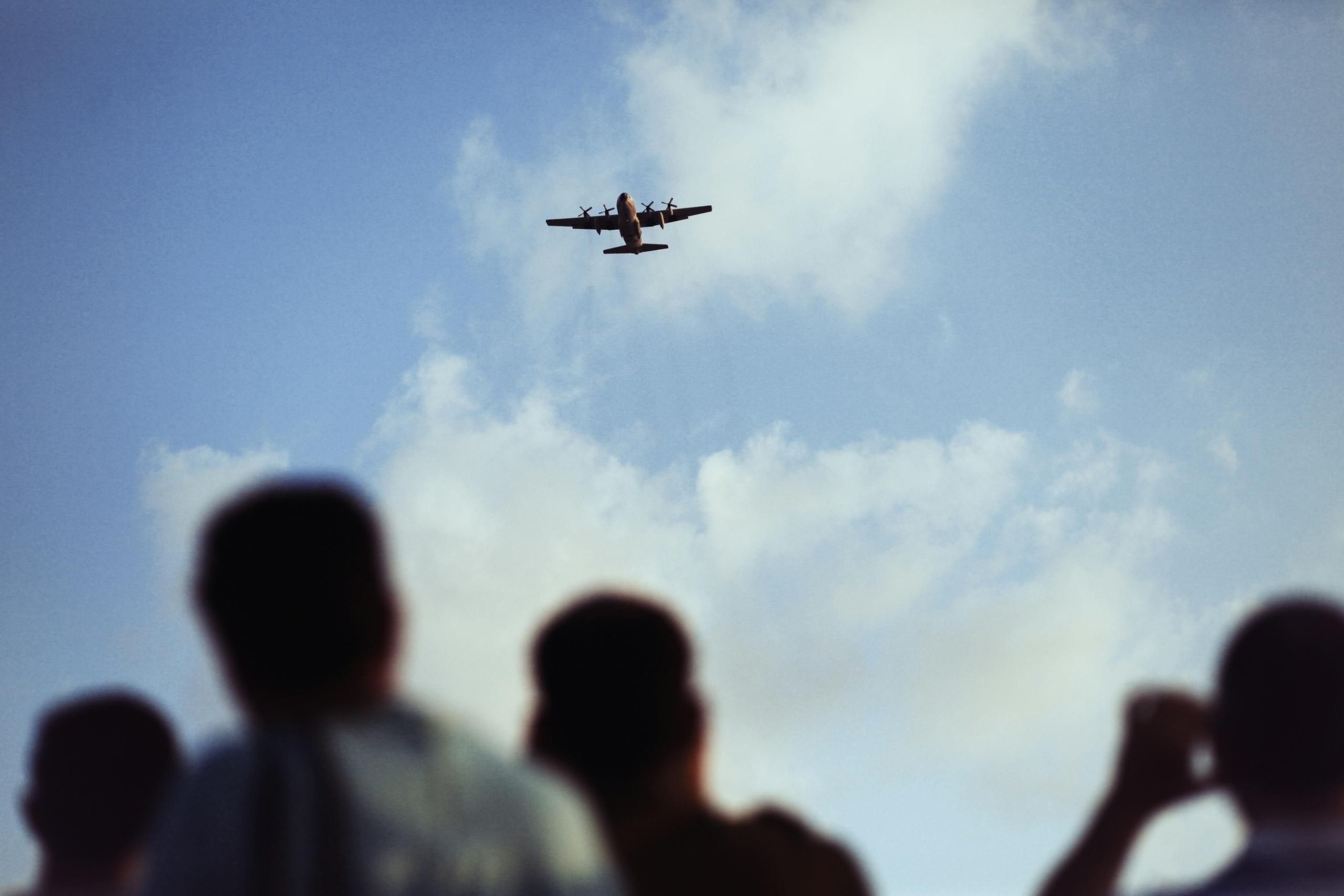 Un avion vole au-dessus d'une foule.