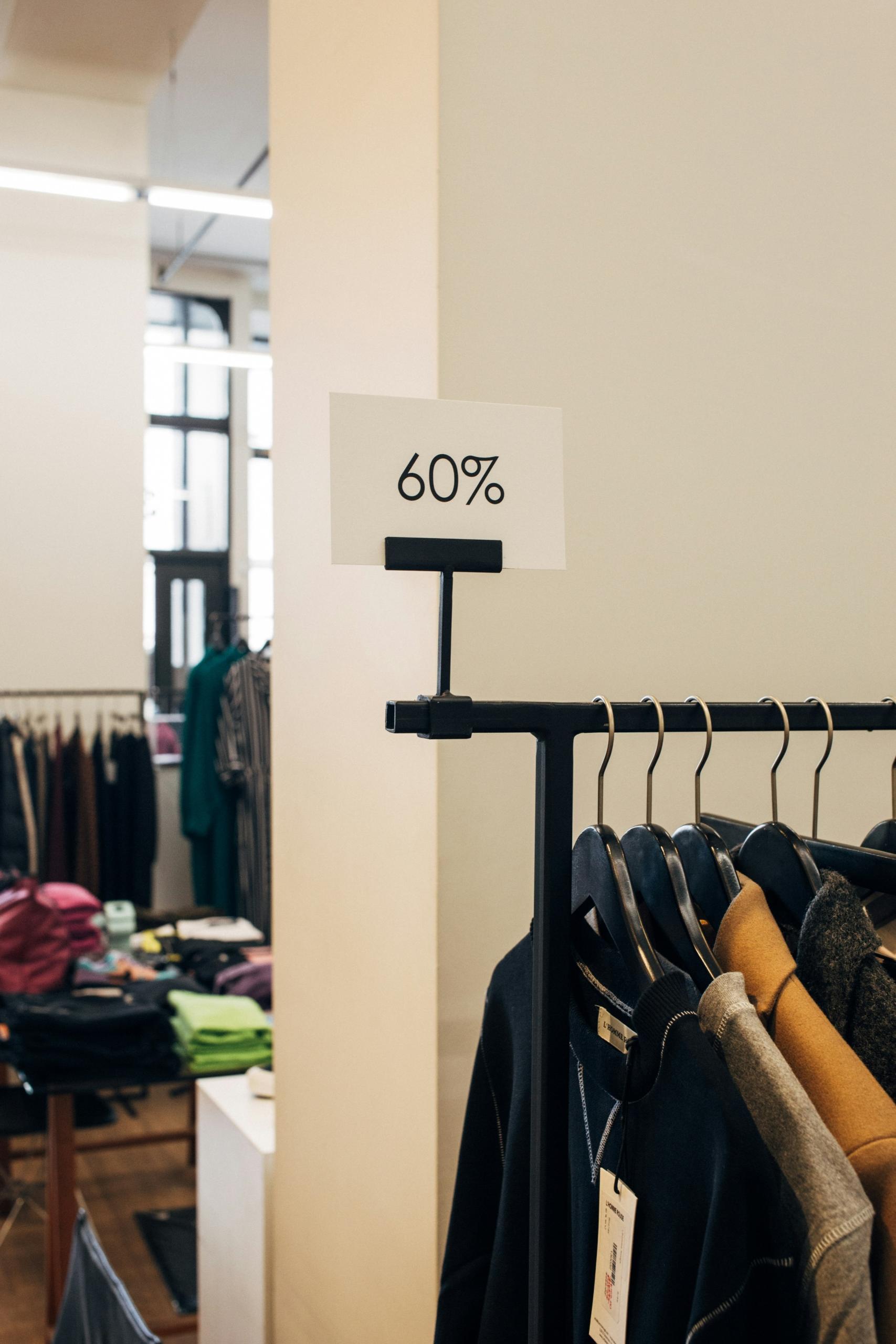 Un portant de vêtements en promotion dans une boutique.