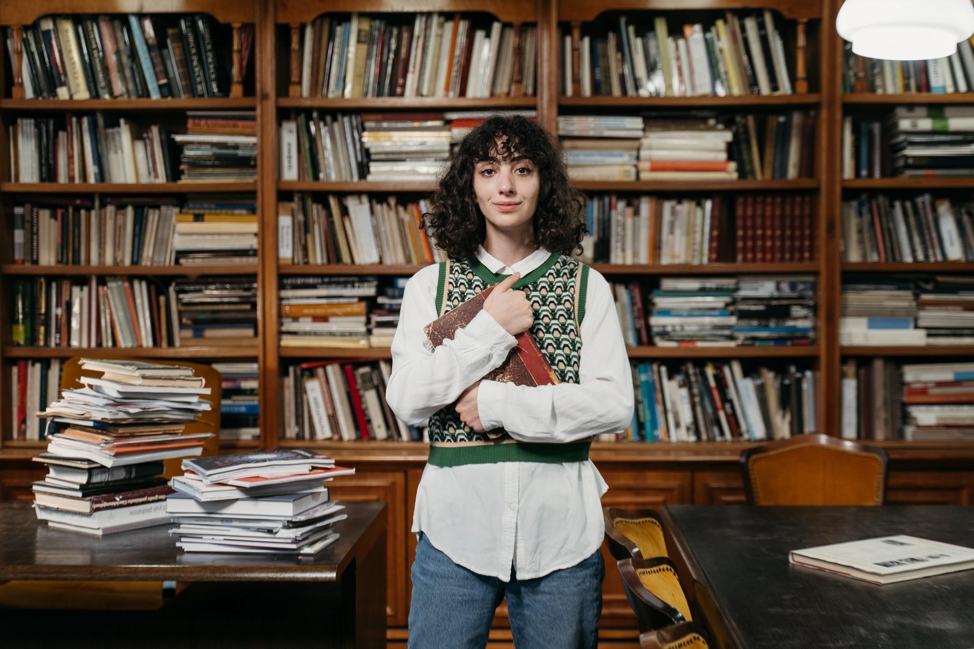 Une jeune femme dans une librairie tenant un livre.