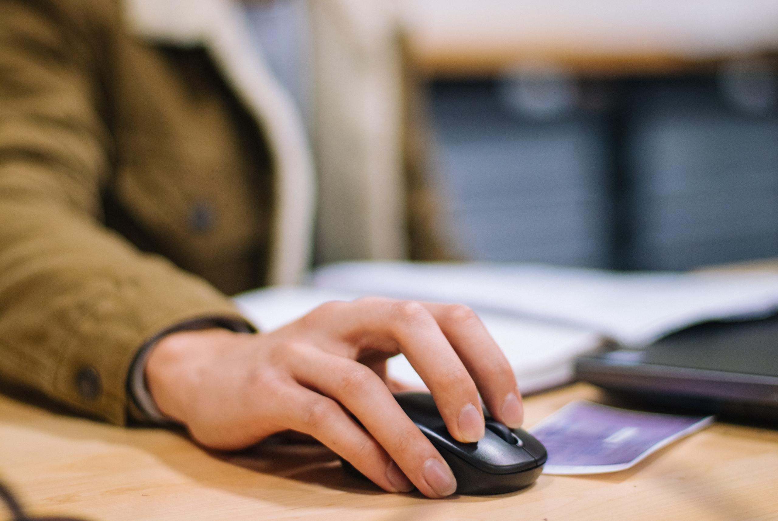 Un main posée sur une souris, prête à faire des exercices de maths.