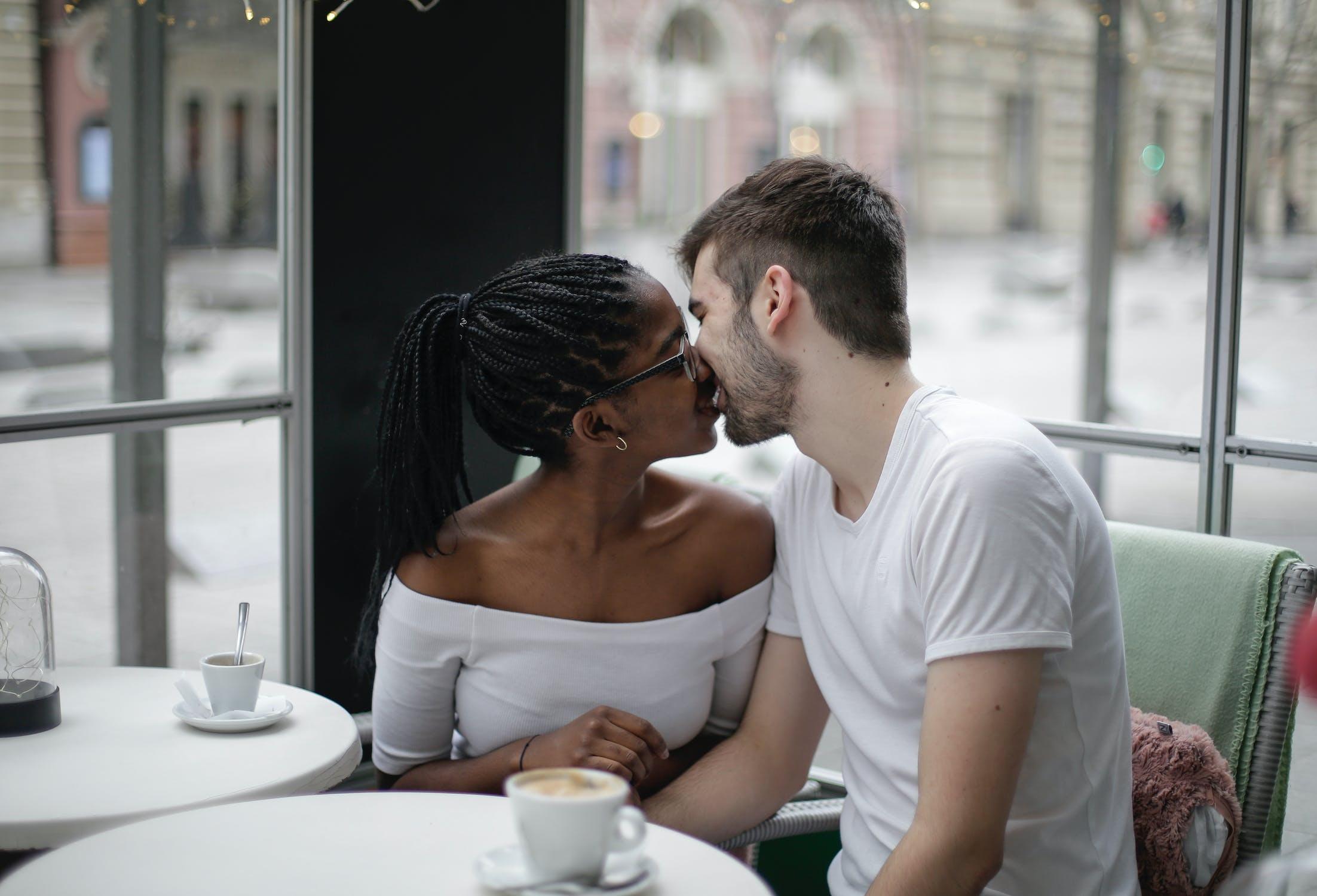 Un couple s'embrasse dans un café. 