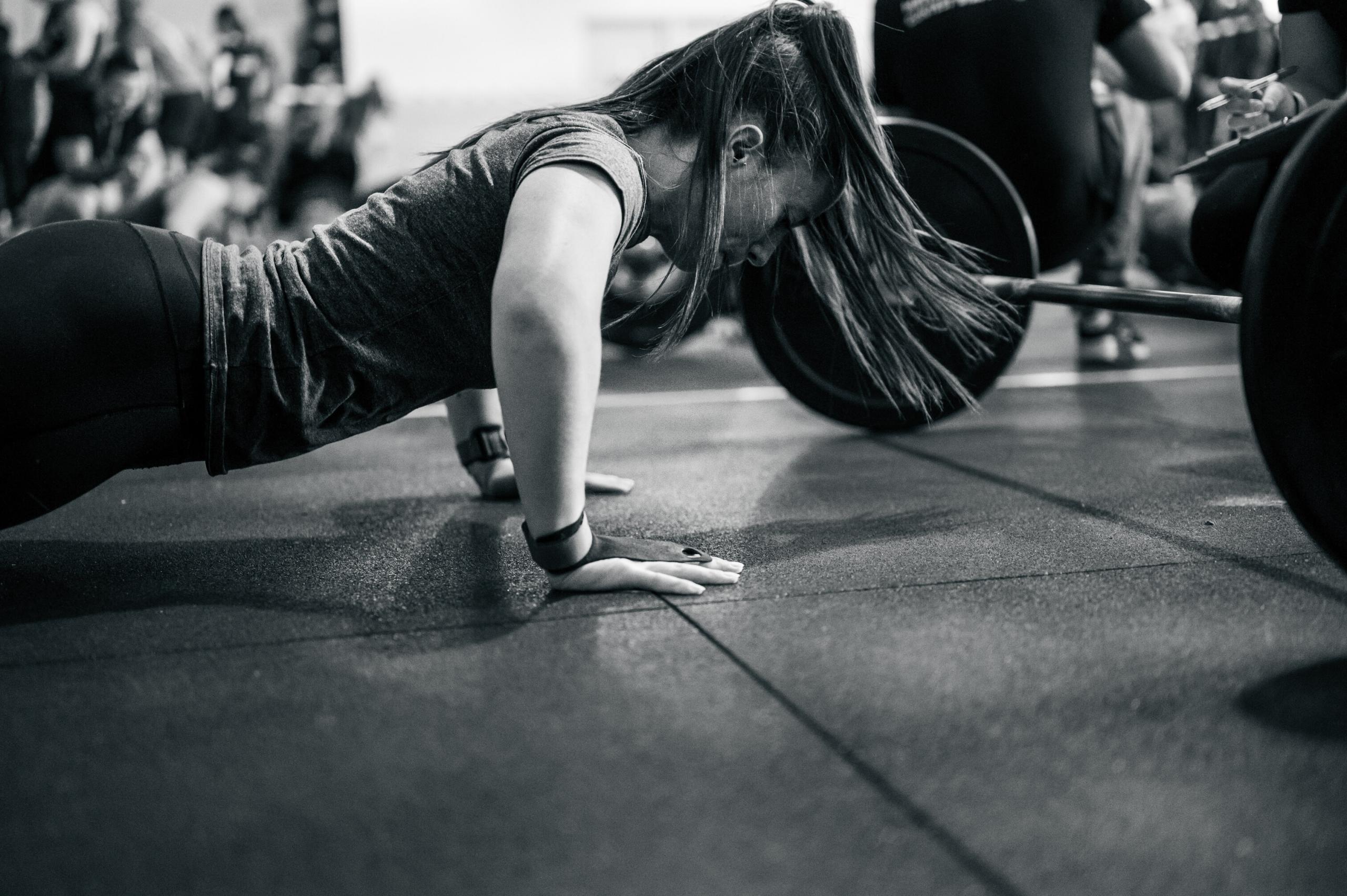 Une femme fait des pompes pour se préparer à la boxe