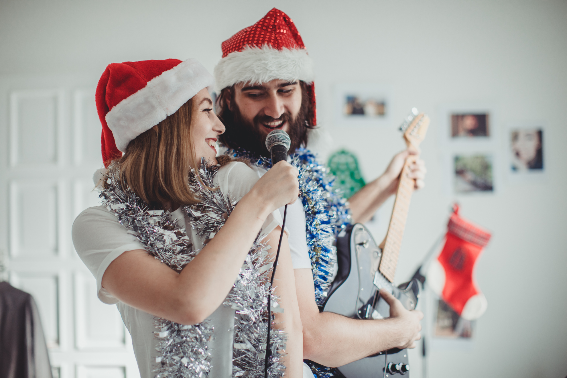 Deux personnes en train de chanter avec des bonnets de Noël.