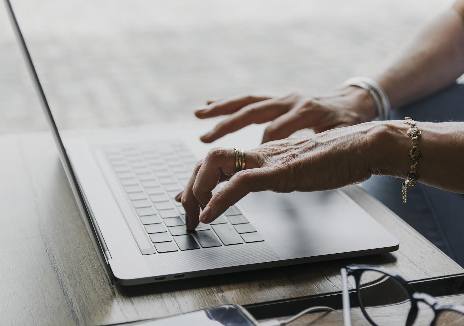 Une femme est en train d'écrire sur un clavier d'ordinateur.
