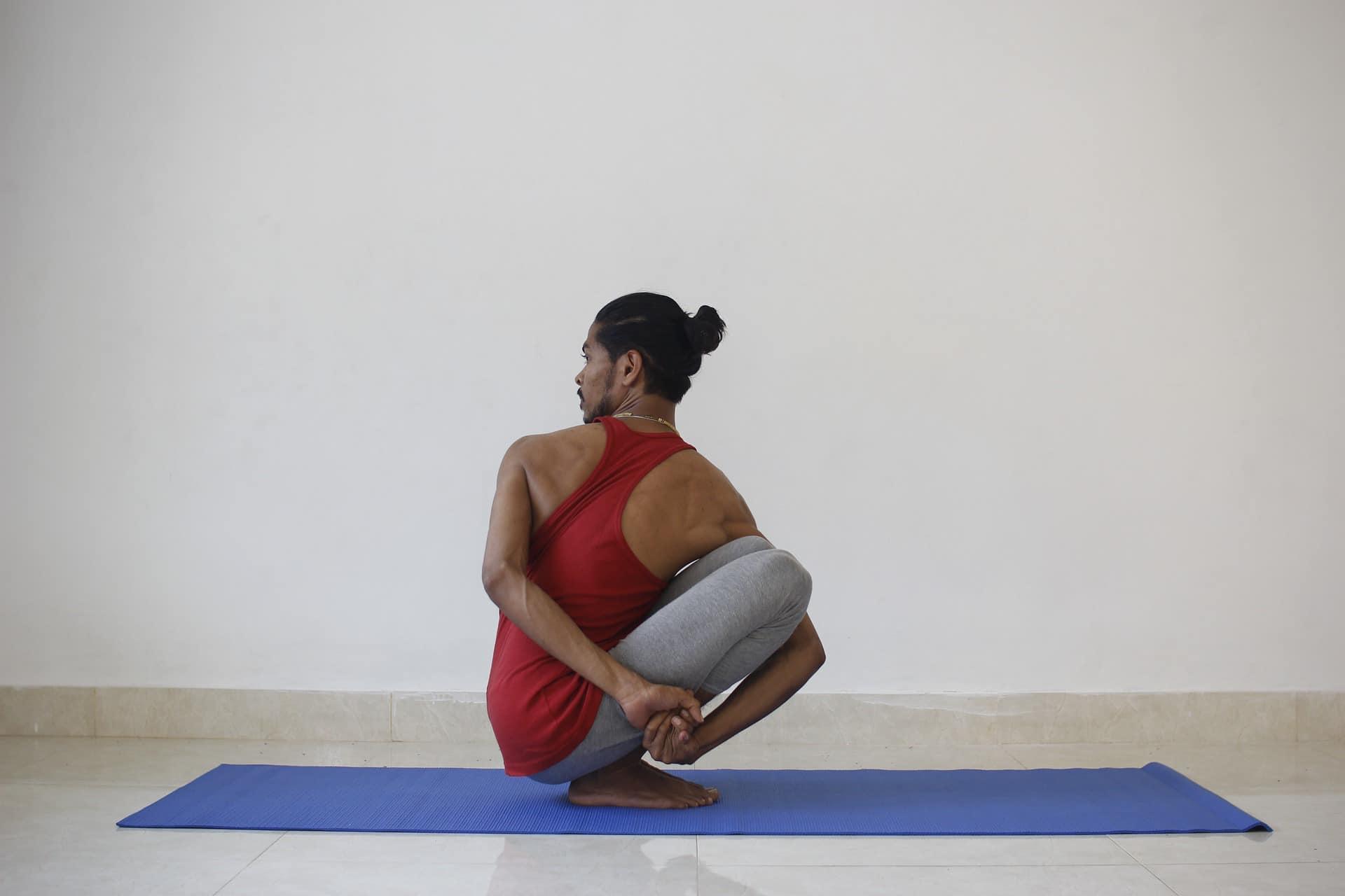 Homme en position de pilates sur un tapis.