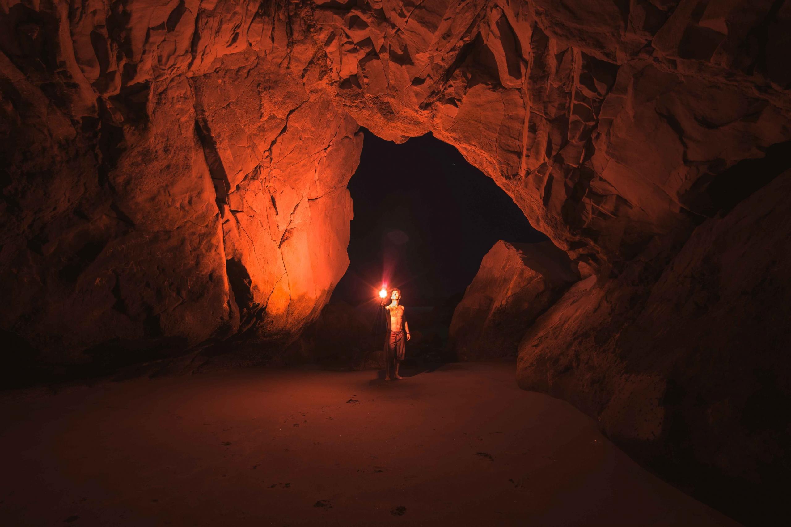 Un homme visite une grotte. 