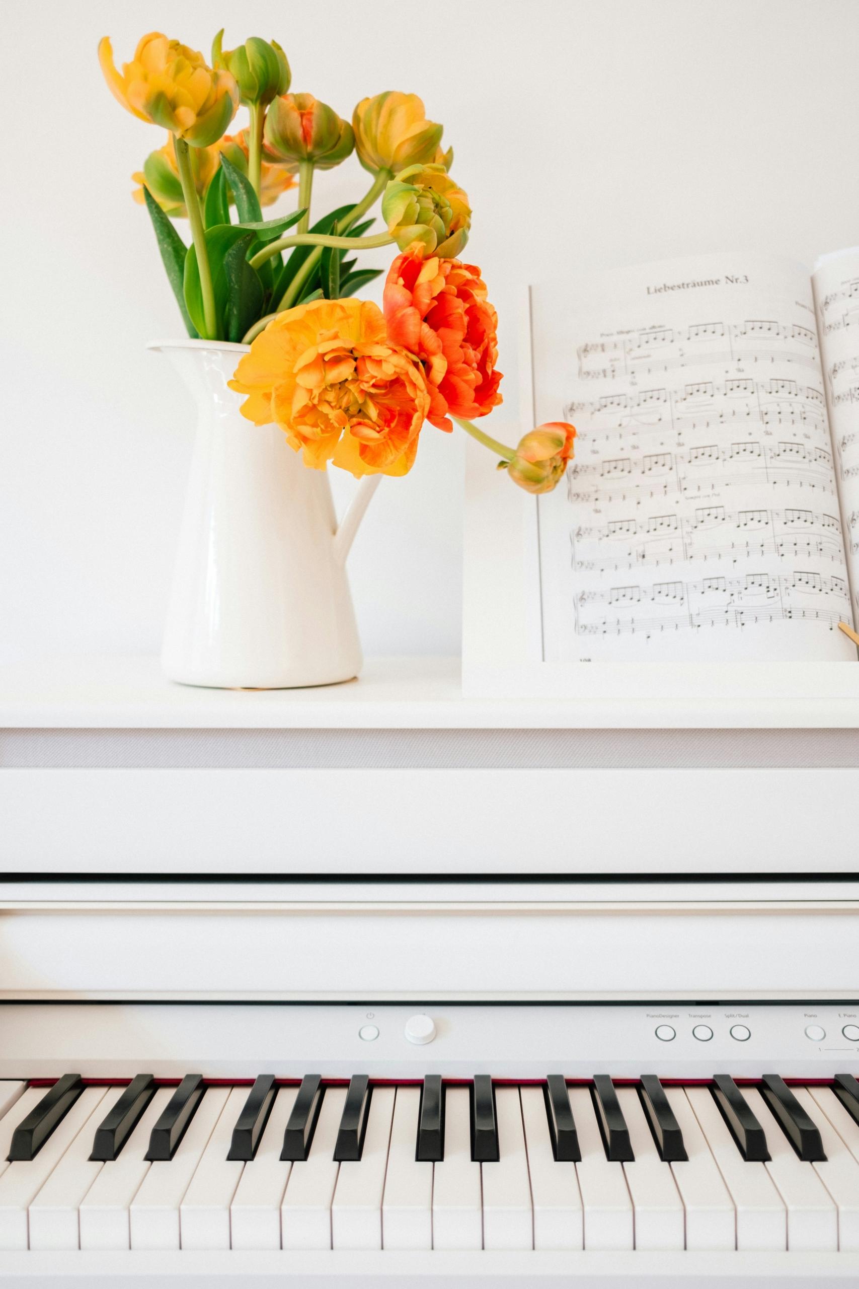 Un piano blanc et un bouquet de fleurs.