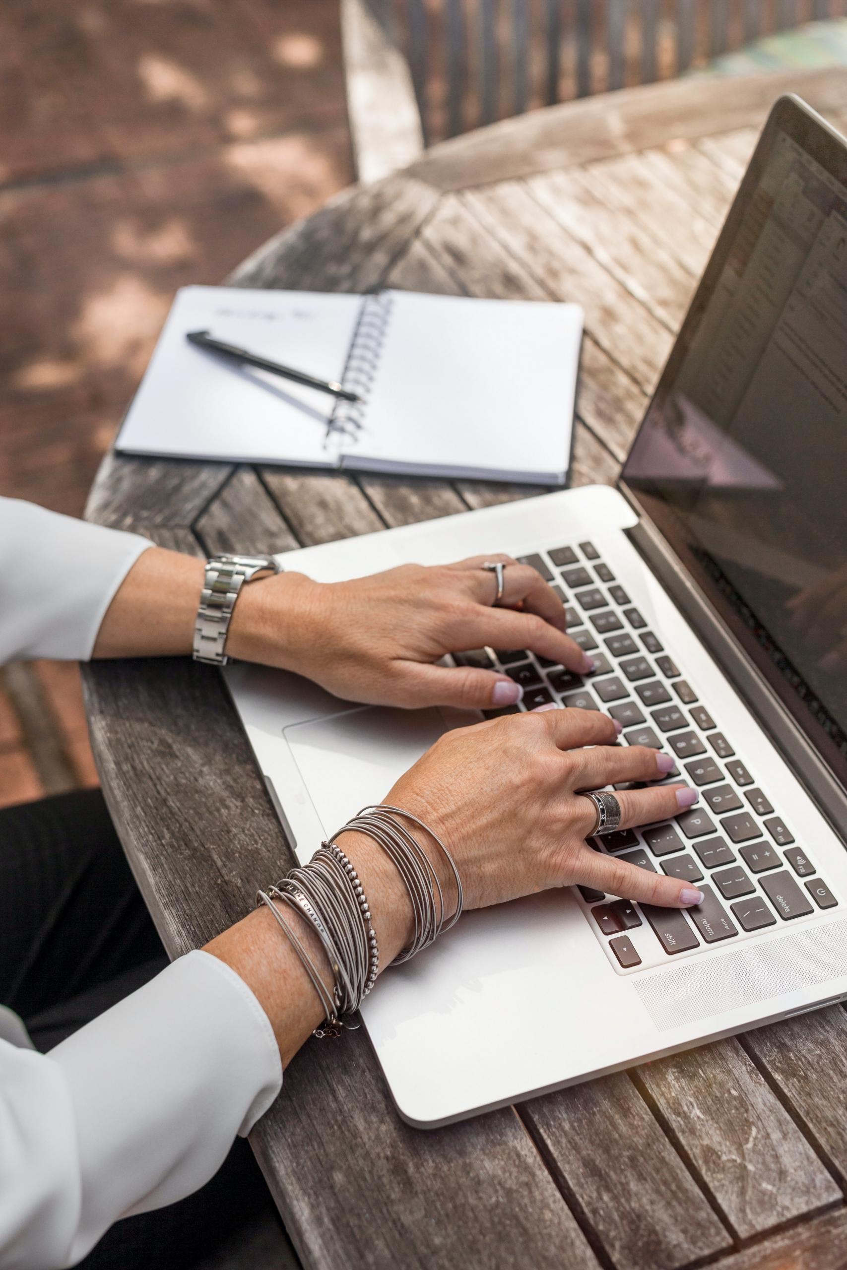 Une femme travaille sur son mac sur un bureau.