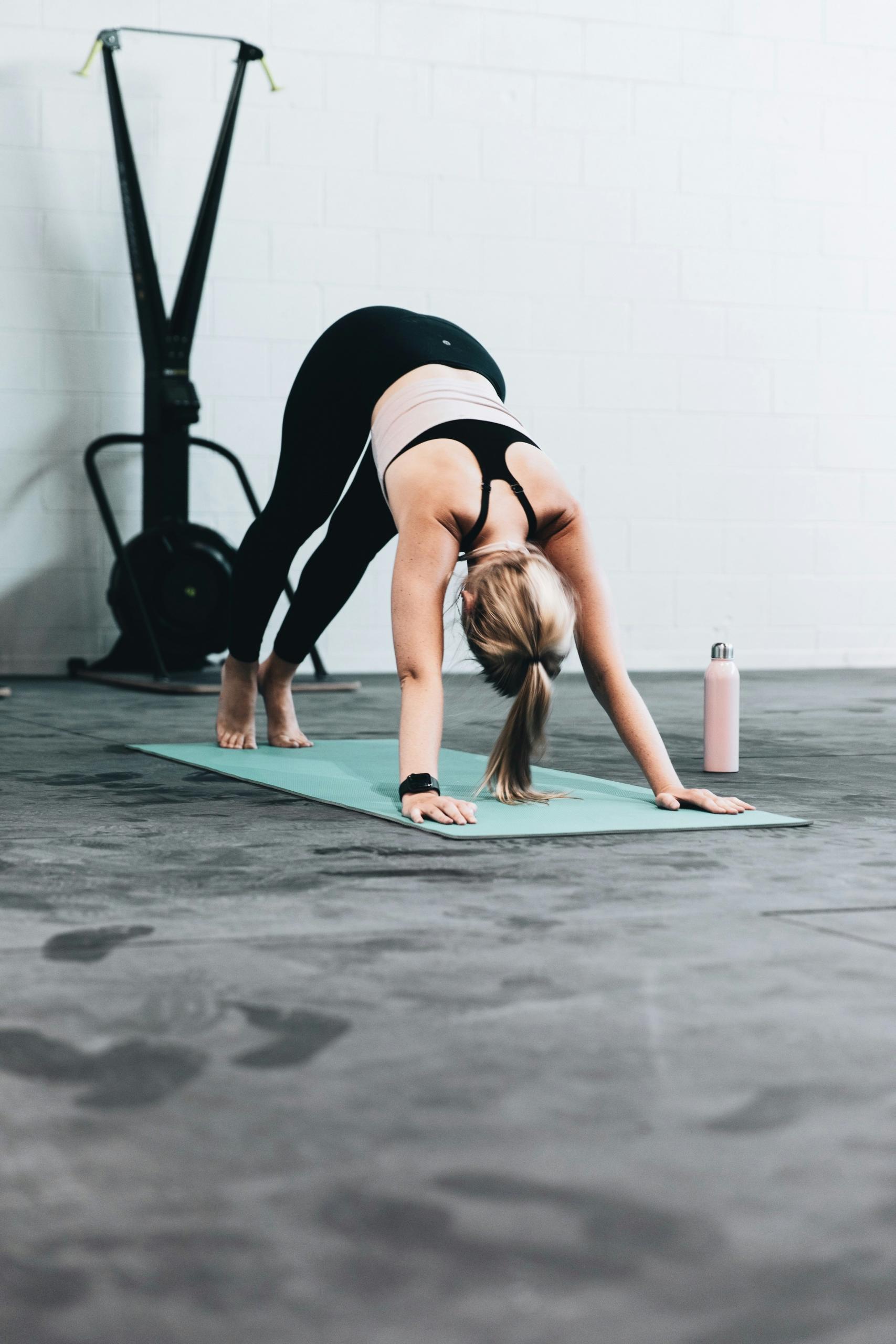 Une femme fait du yoga dans une salle de sport.