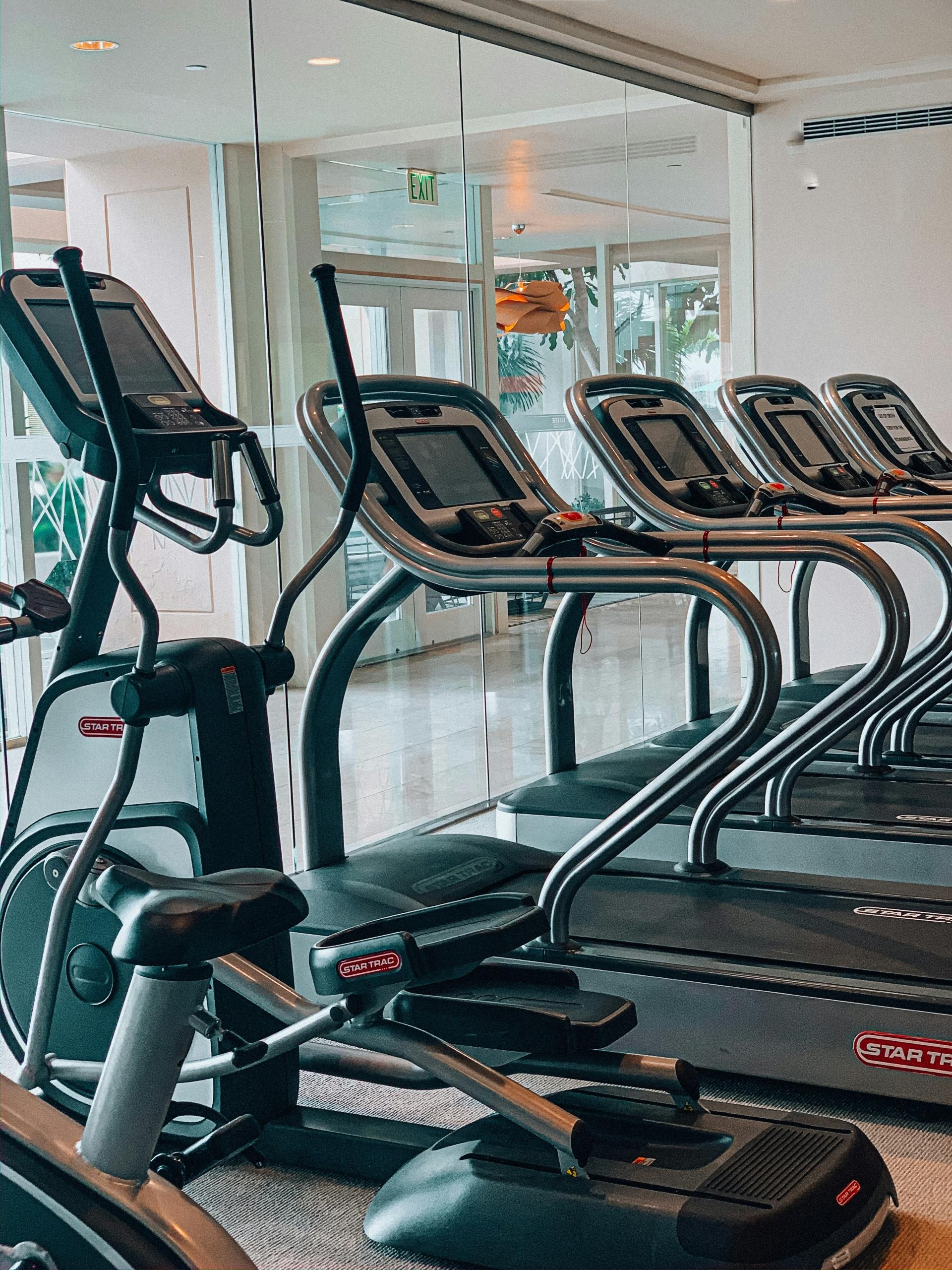 Des tapis de course dans une salle de sport.