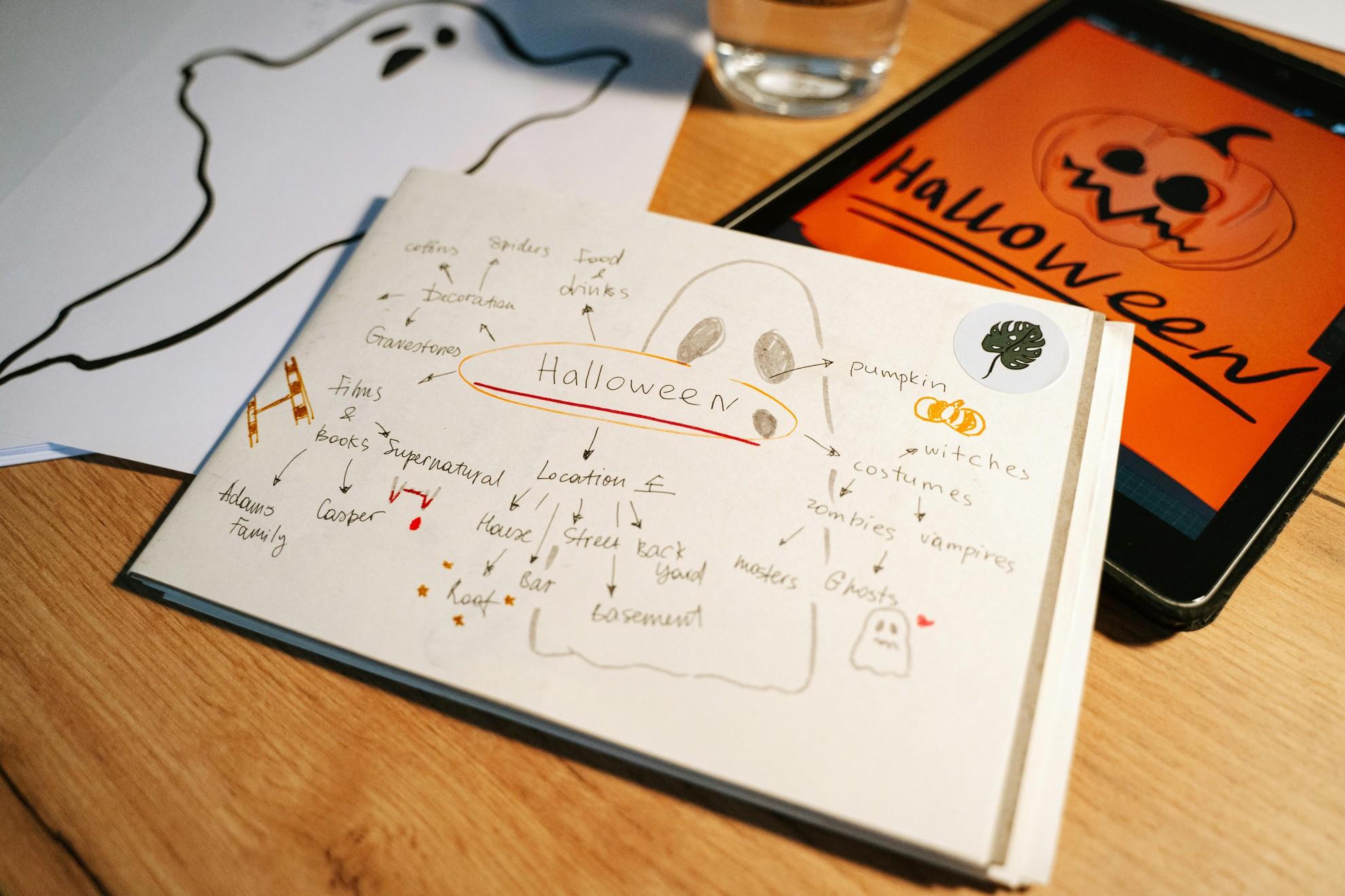Des dessins d'Halloween sur carnet et tablette numérique.
