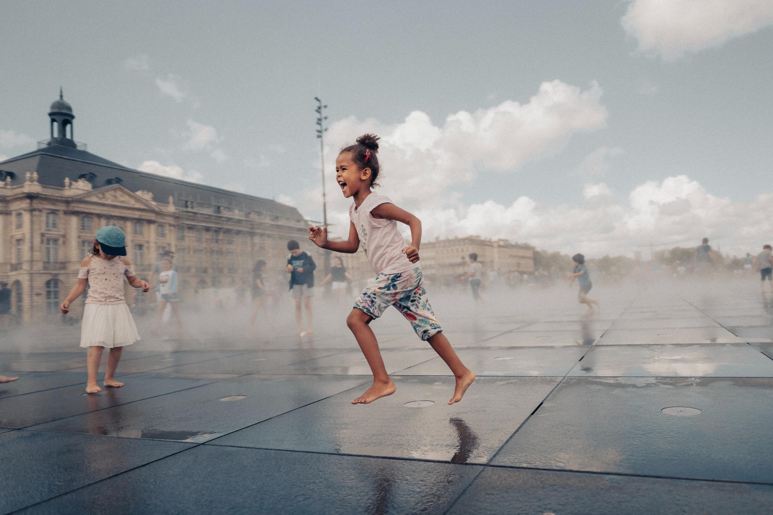 Une fillette court sur la place de la Bourse à Bordeaux
