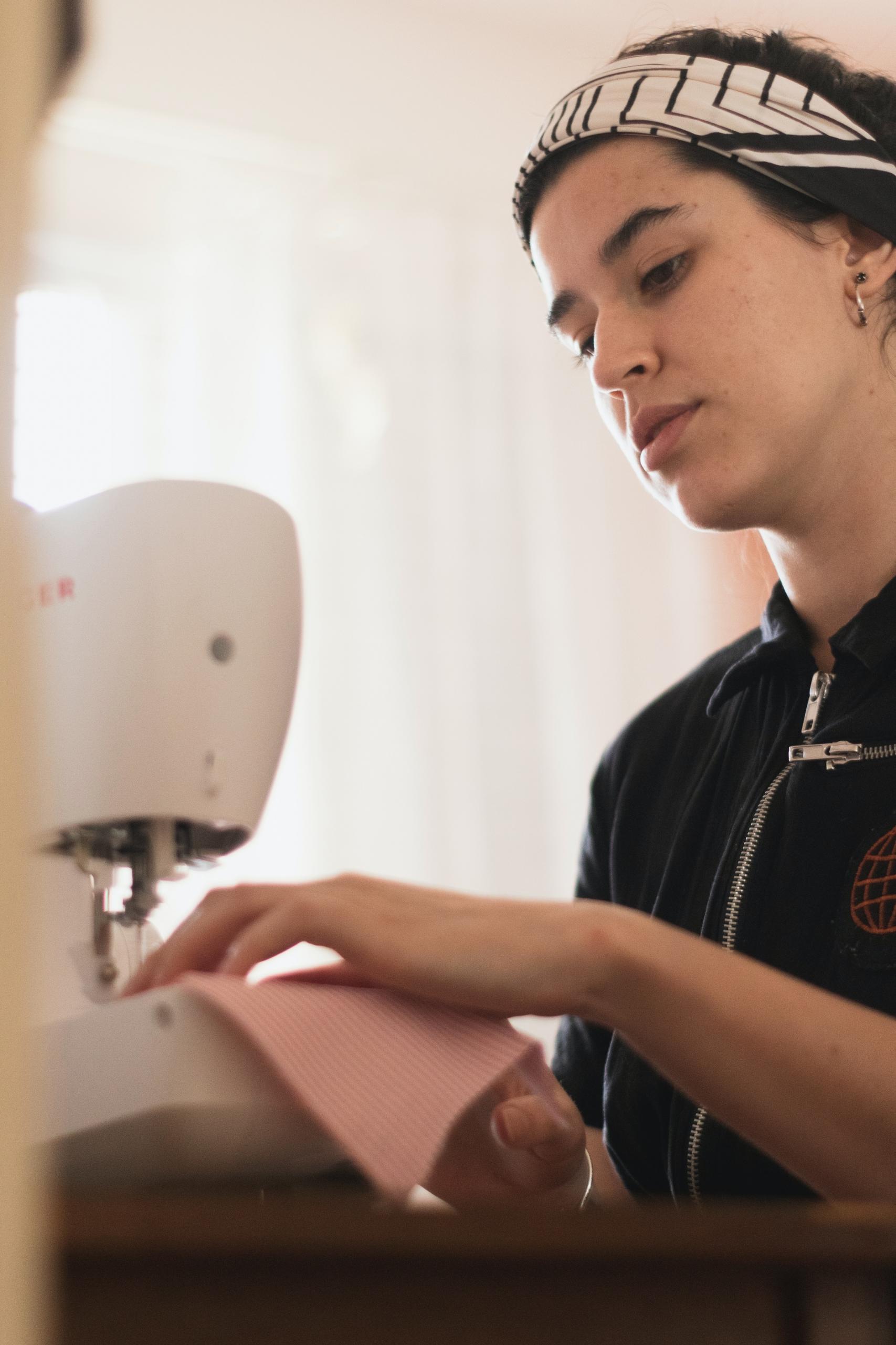 Une couturière débutant devant une machine à coudre