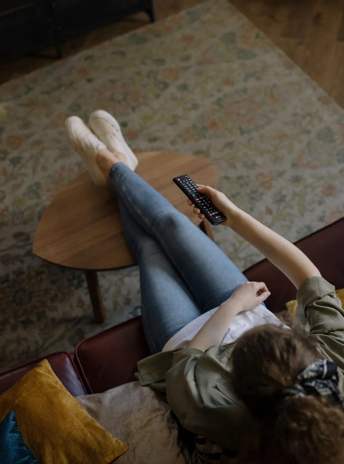 Une femme regarde la télévision. 