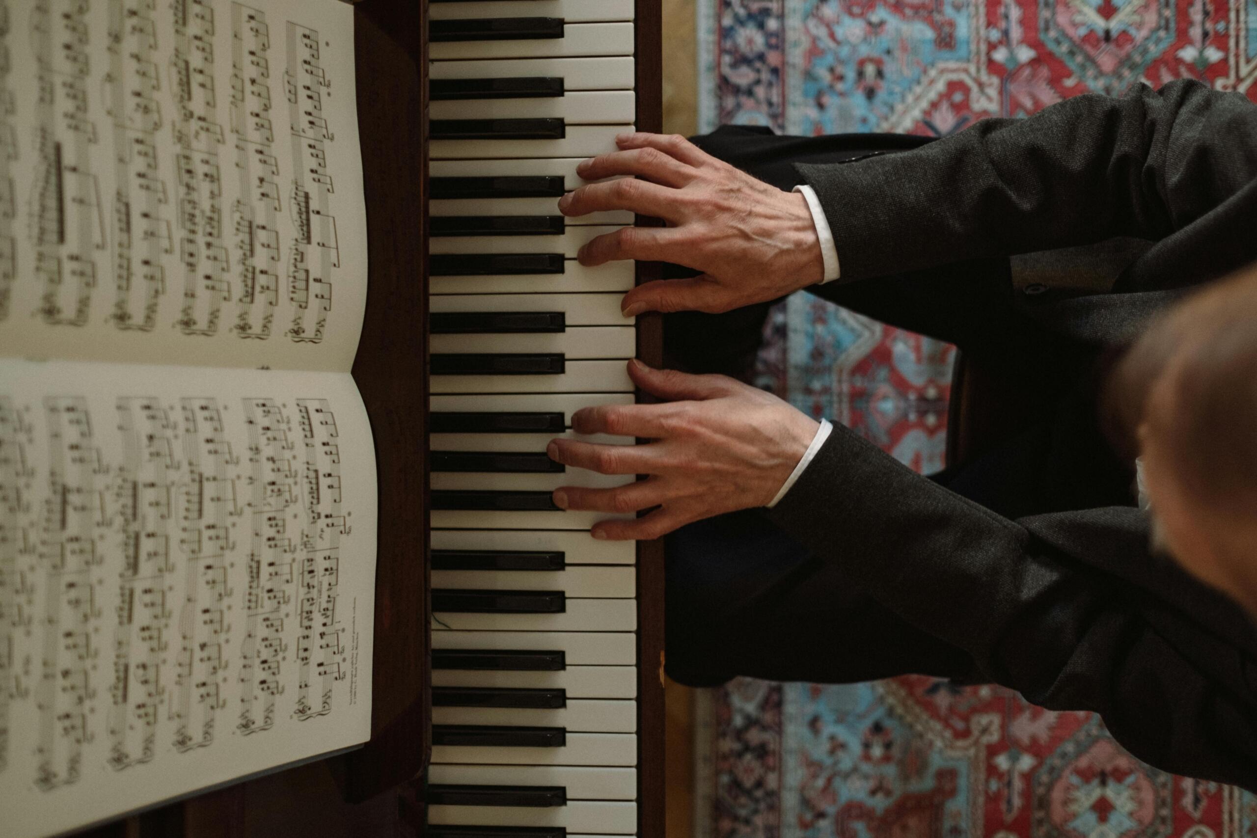 Un pianiste lit une partition en jouant du piano.