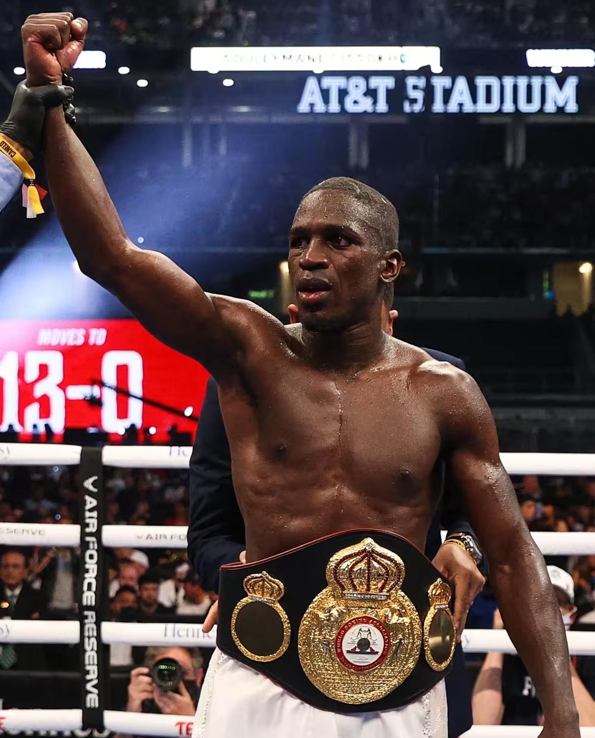 Souleymane Cissokho lève le bras sur un ring après une victoire.