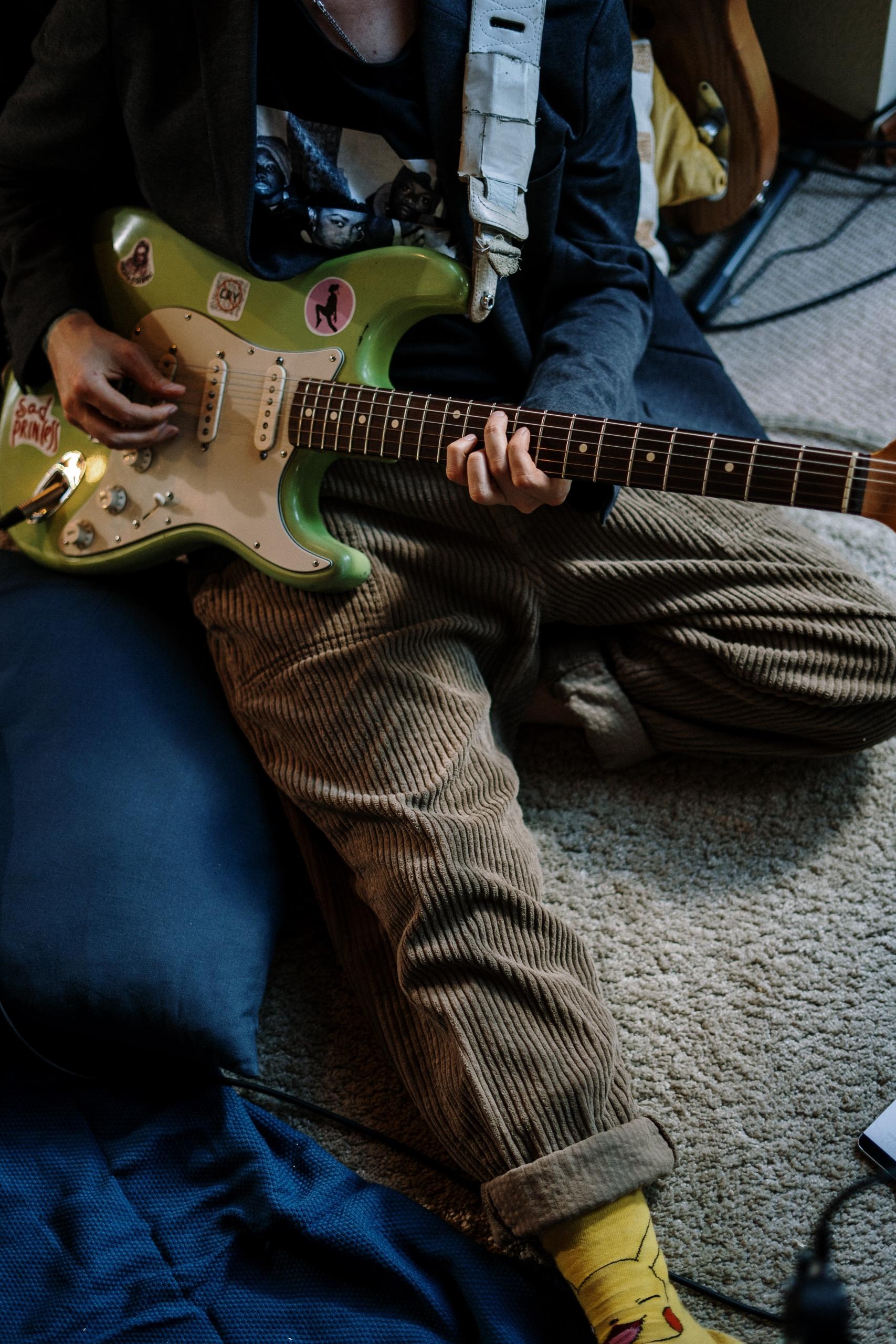 quelqu'un faisant de la guitare assis