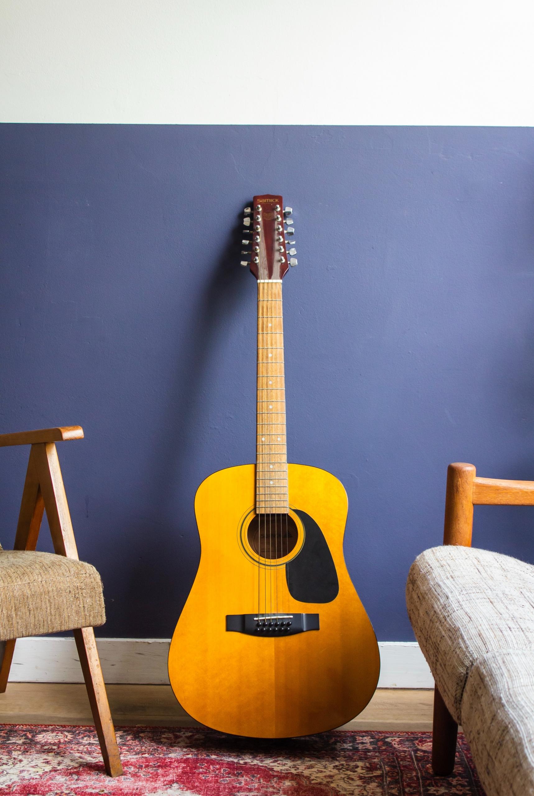 Une première guitare posée contre un mur.