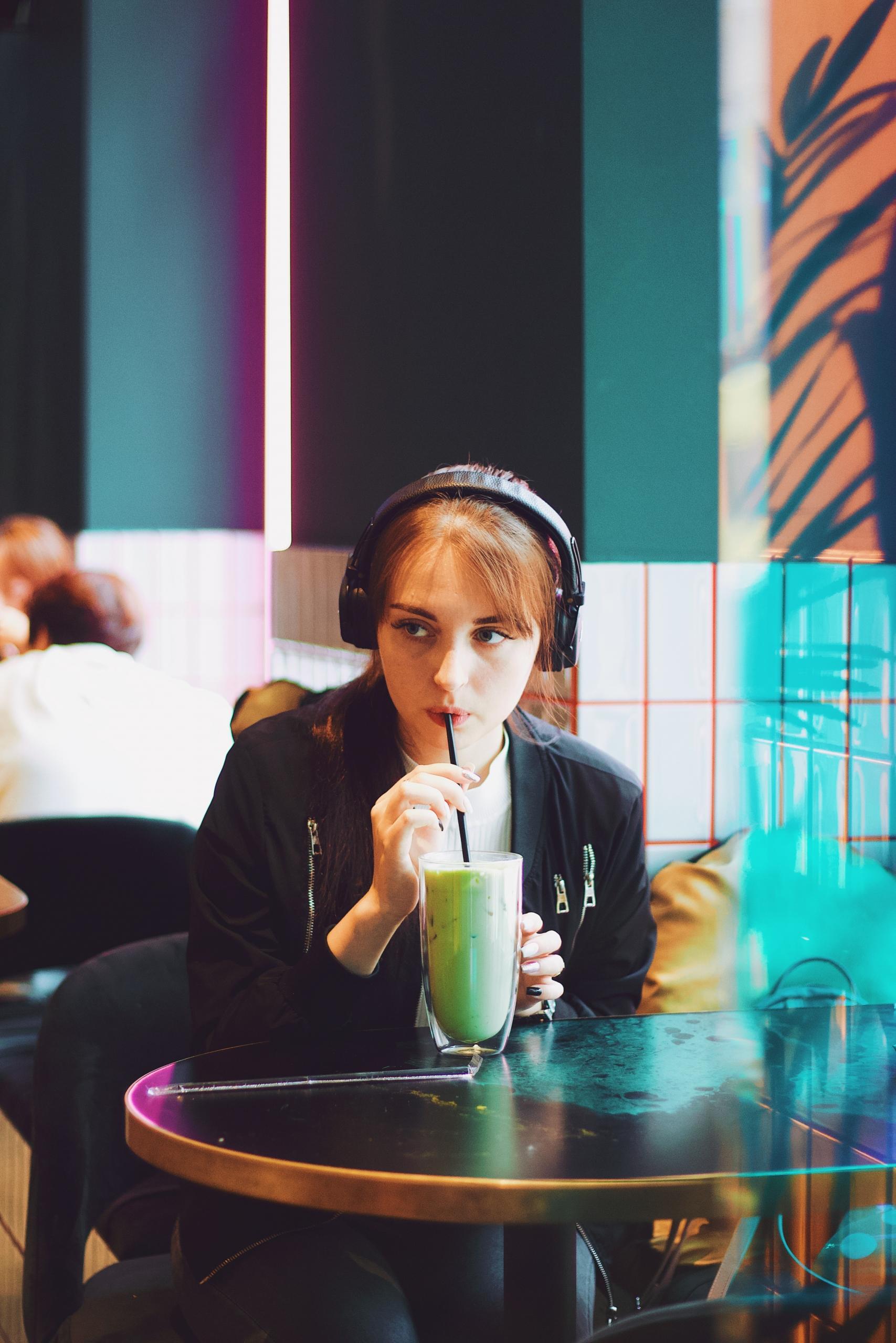 Une lycéenne révise son bac en podcast dans un café.