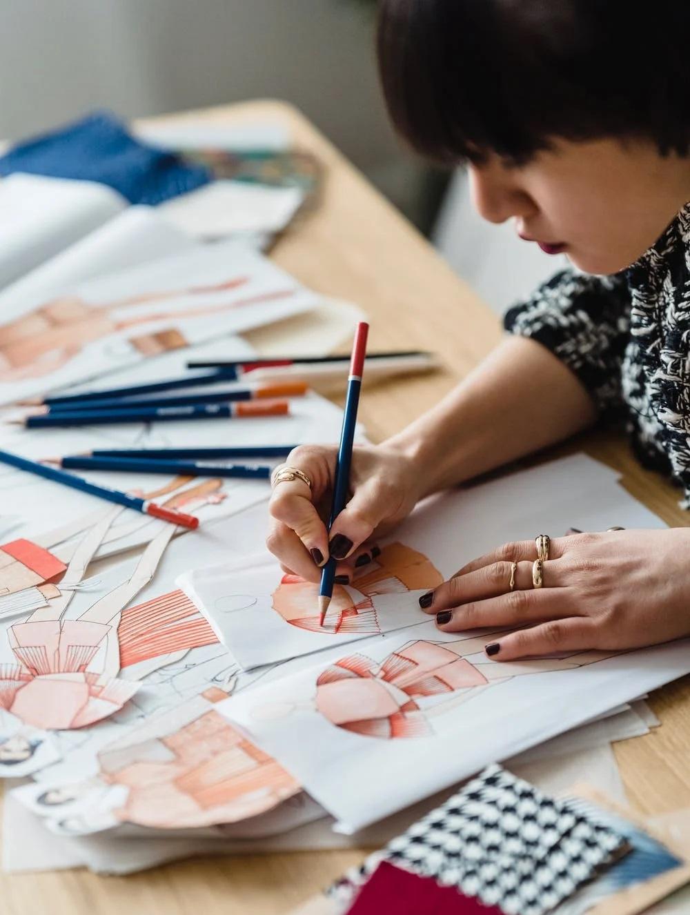 Une femme réalise des dessins de mode.